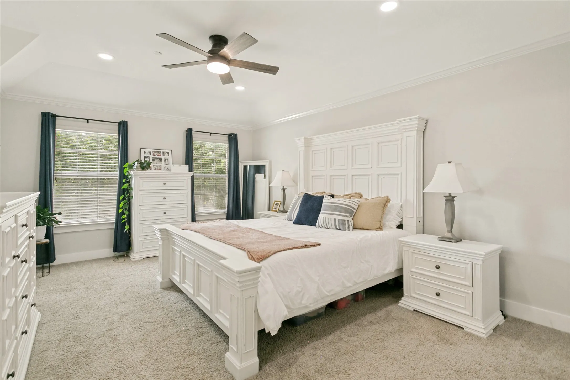 Recessed ceiling lighting, crown molding, and a ceiling fan