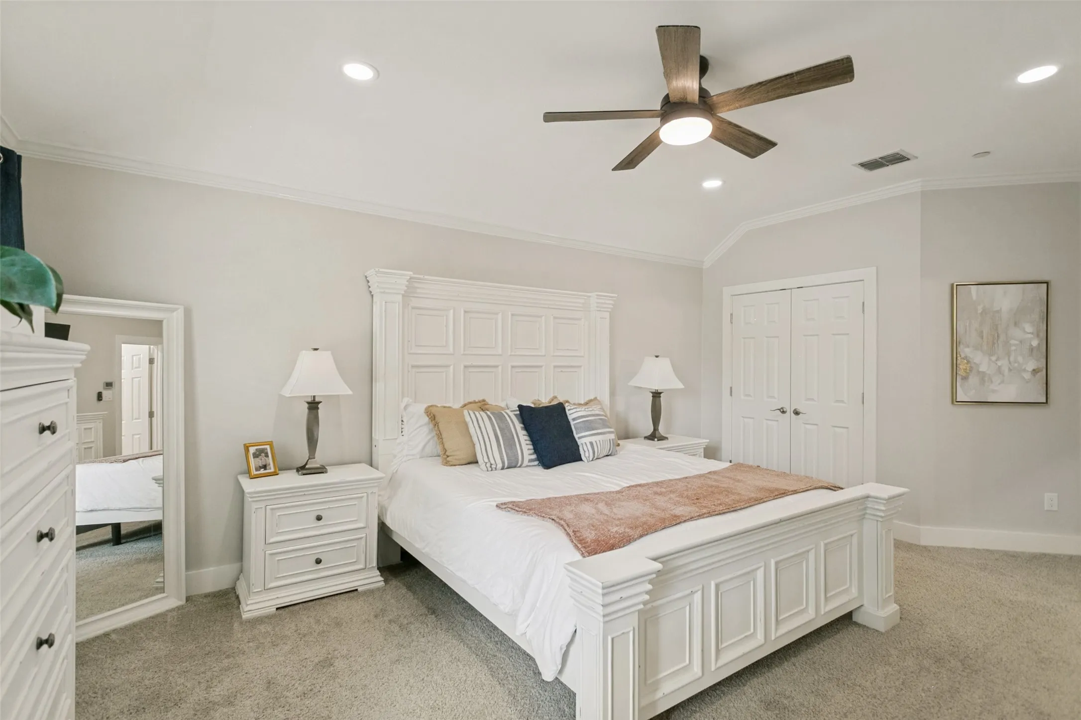 Tray ceiling with recessed lighting and a ceiling fan, white paneled double doors, and light-colored carpet flooring
