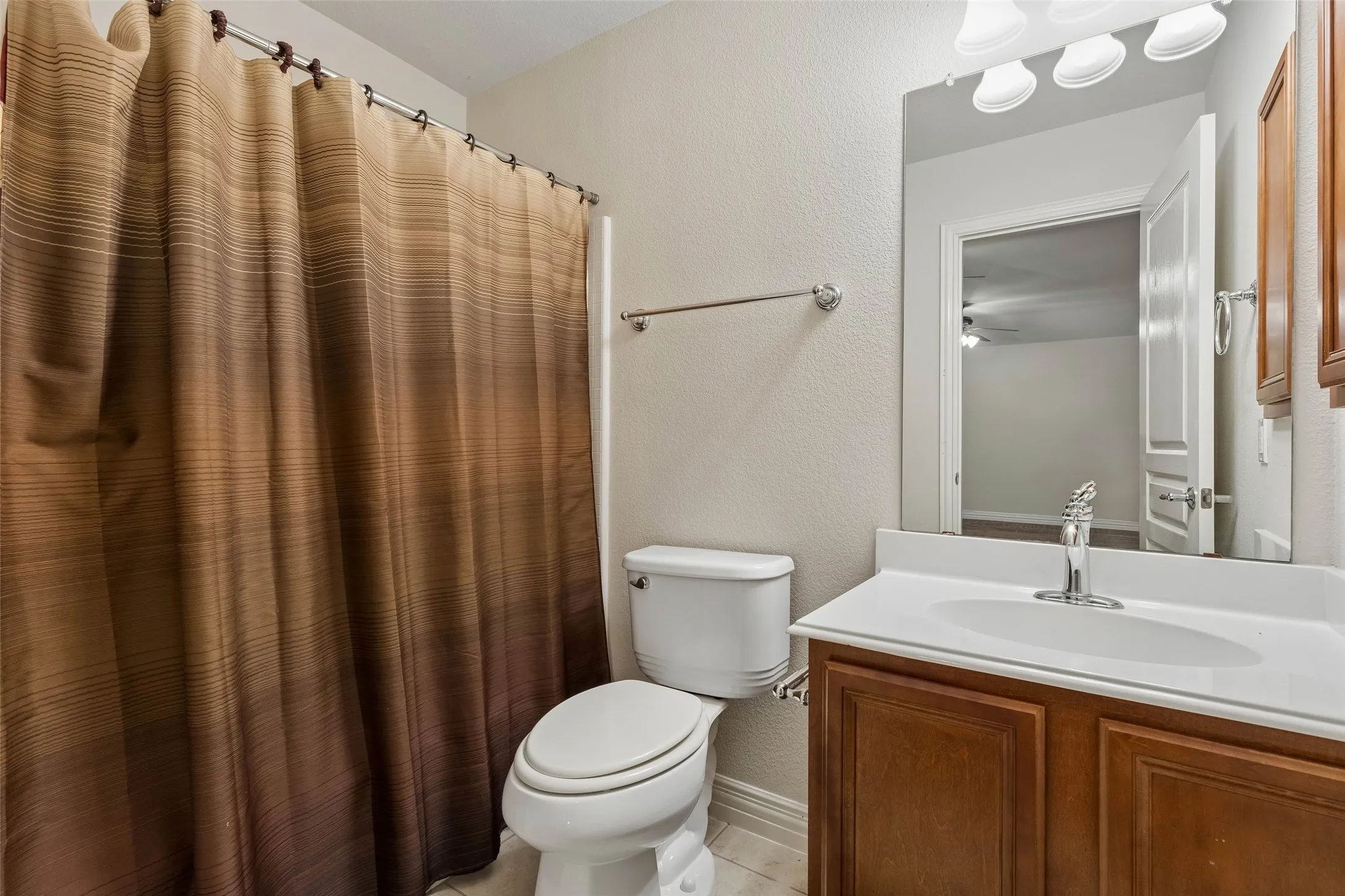 Vanity with integrated sink, chrome faucet, and wood-finish cabinetry