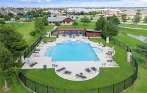 Expansive community pool with integrated spa, surrounded by a concrete deck and lush green​​‌​​​​‌​​‌‌​‌‌​​​‌‌​‌​‌​‌​​​‌​​ landscaping