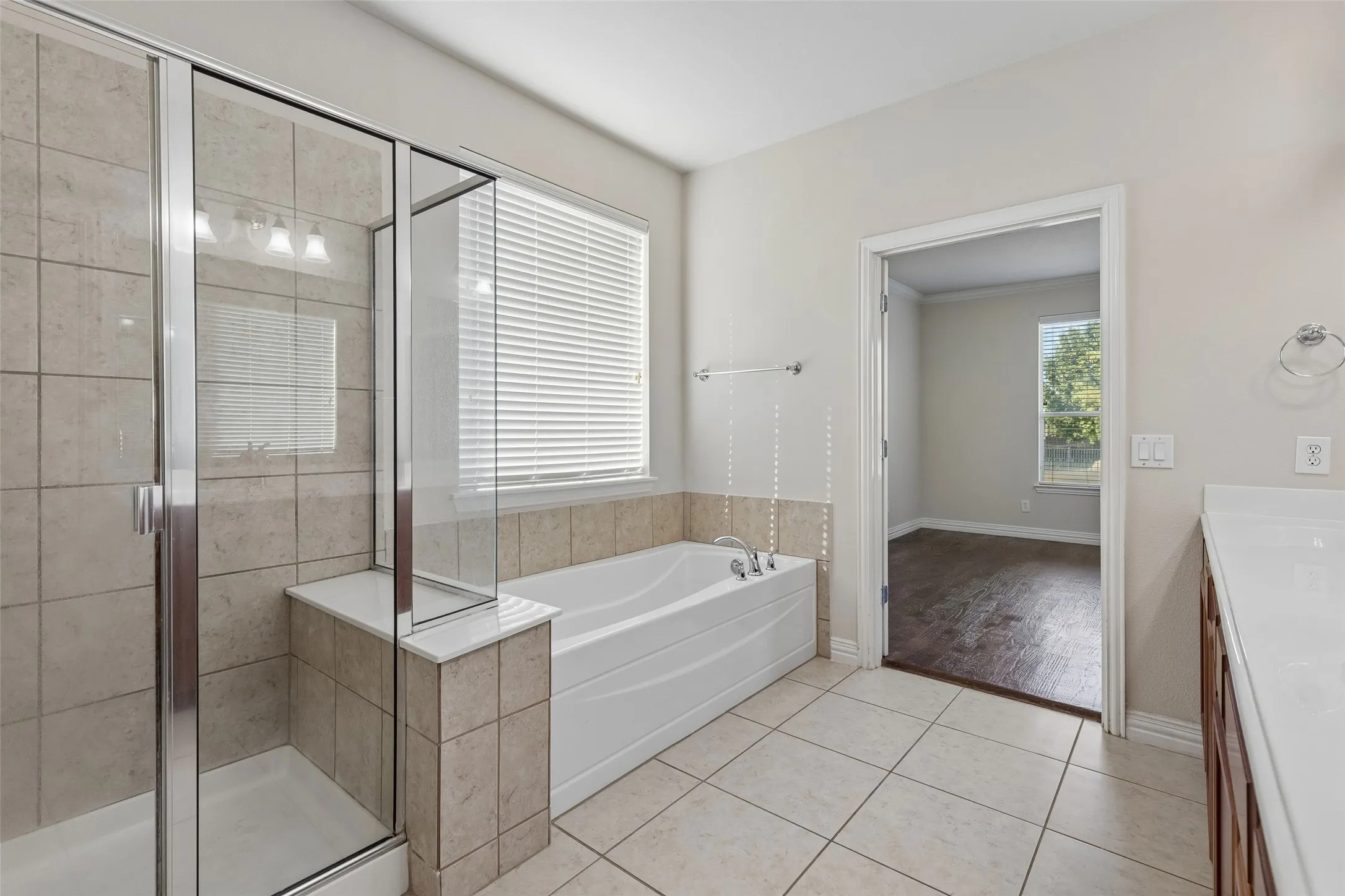 Tiled walk-in shower, soaking tub with tiled surround, and ceramic tile flooring
