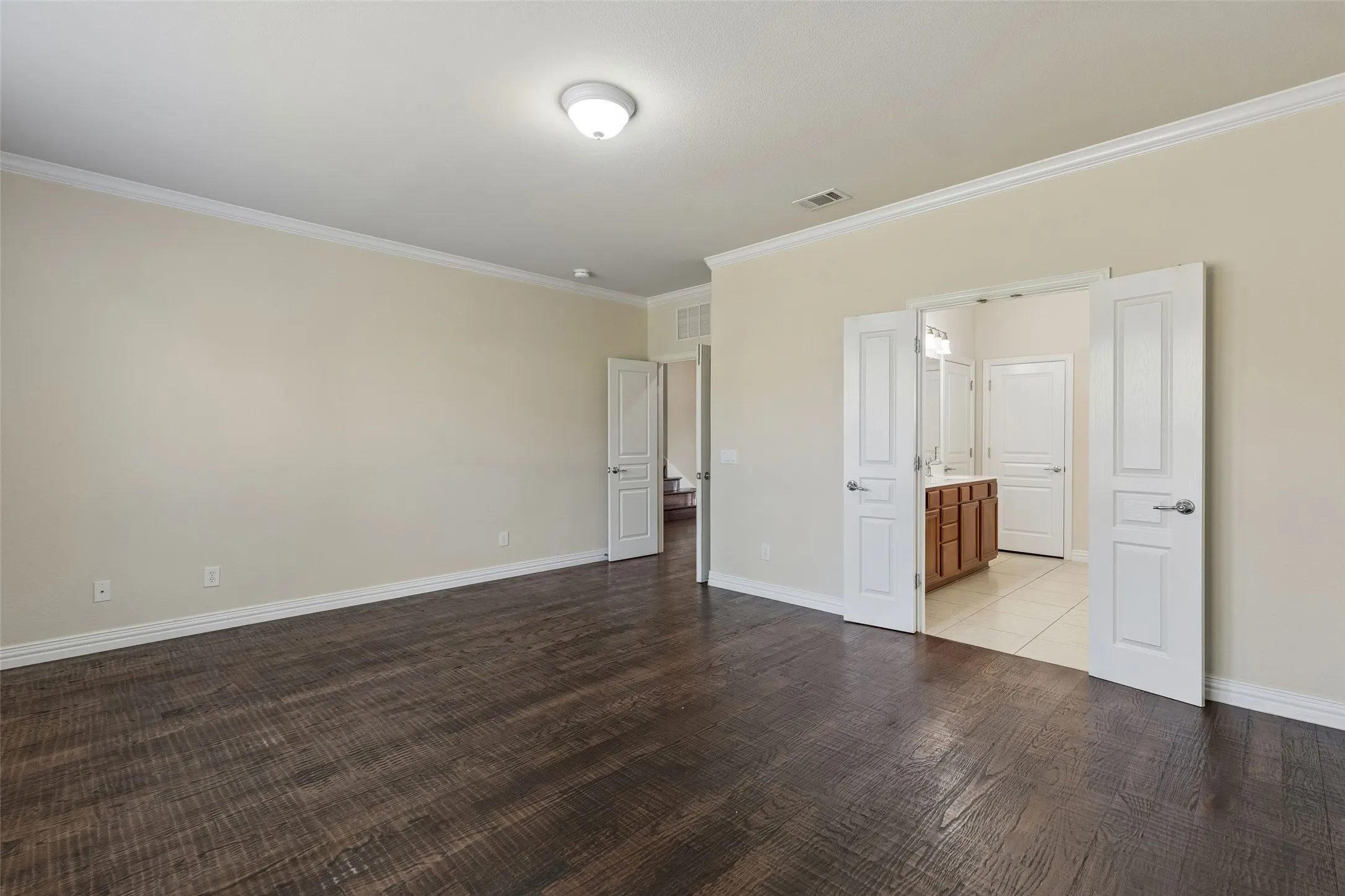 Wood-finish flooring throughout, crown molding, and double panel doors