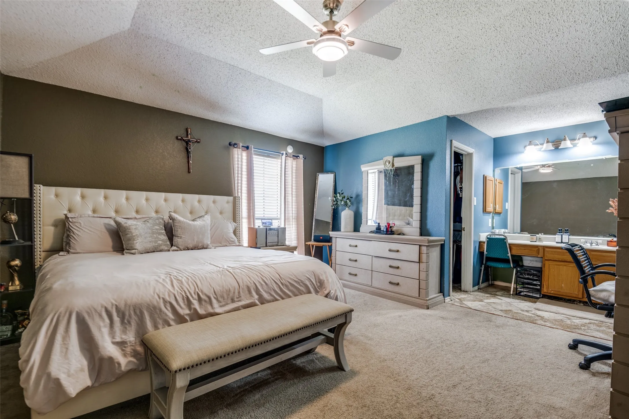 Vaulted ceiling with ceiling fan, dual-tone painted walls, and carpet flooring