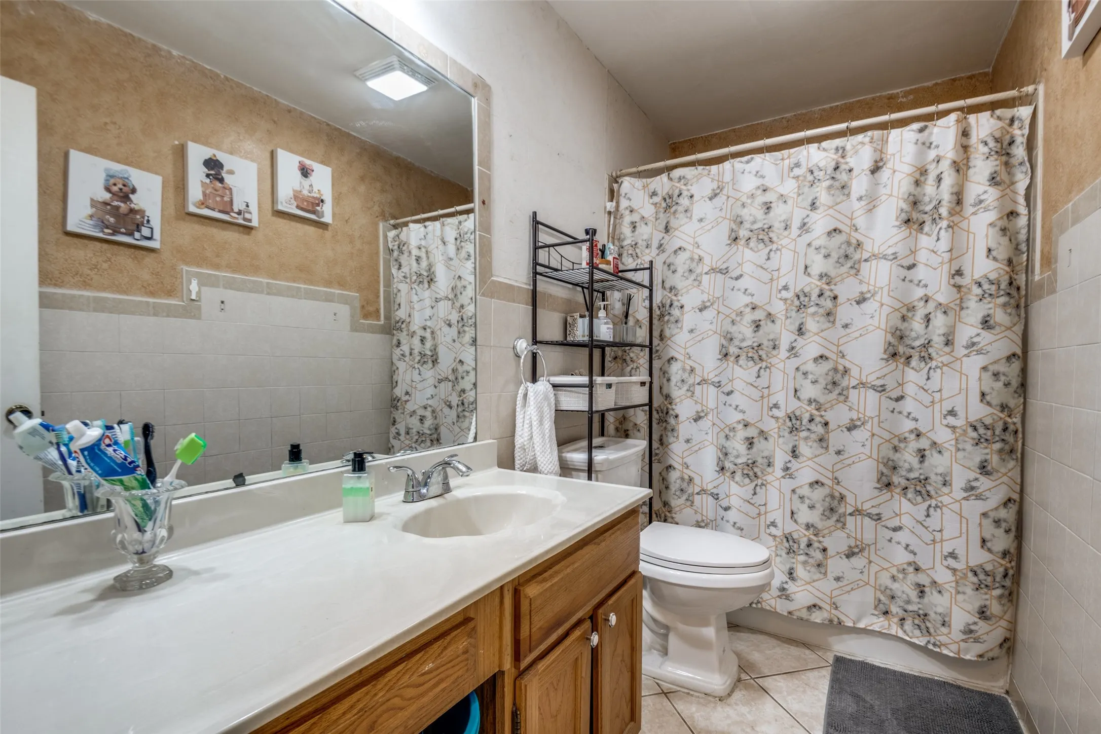 Bathroom featuring a vanity with a light-toned countertop, a built-in sink, and wood-finish cabinetry