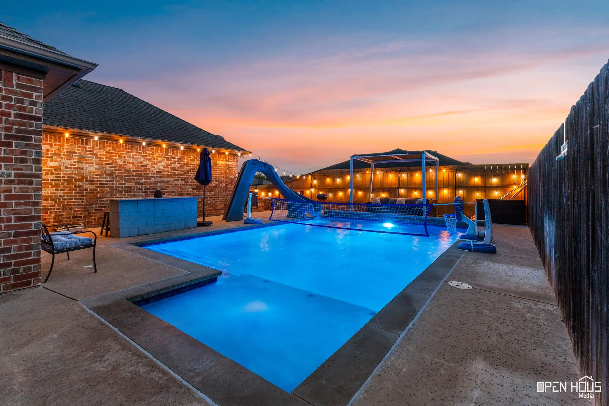 In-ground swimming pool with integrated slide and illuminated water