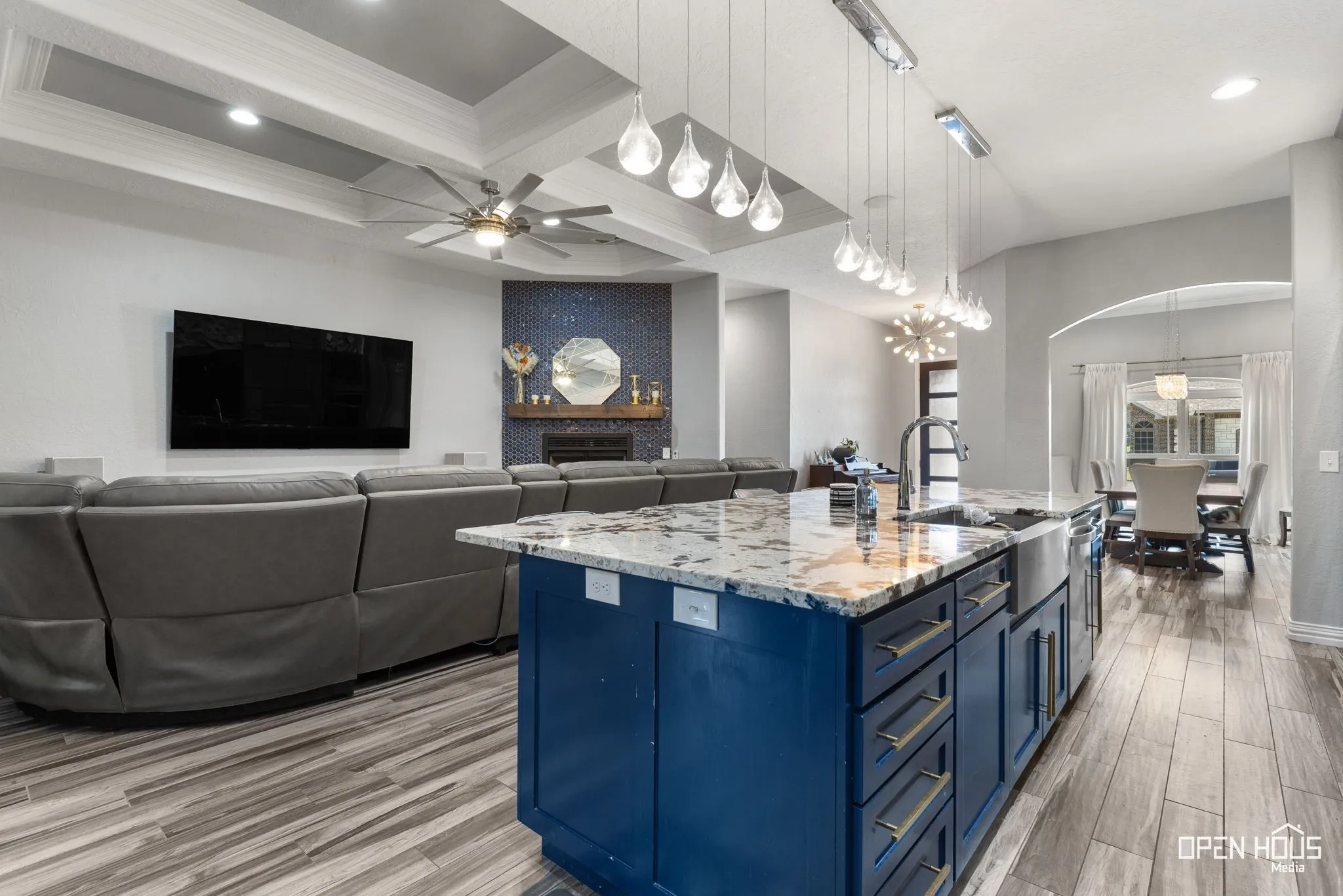 Kitchen island with a granite-style countertop, farmhouse sink, and blue cabinetry