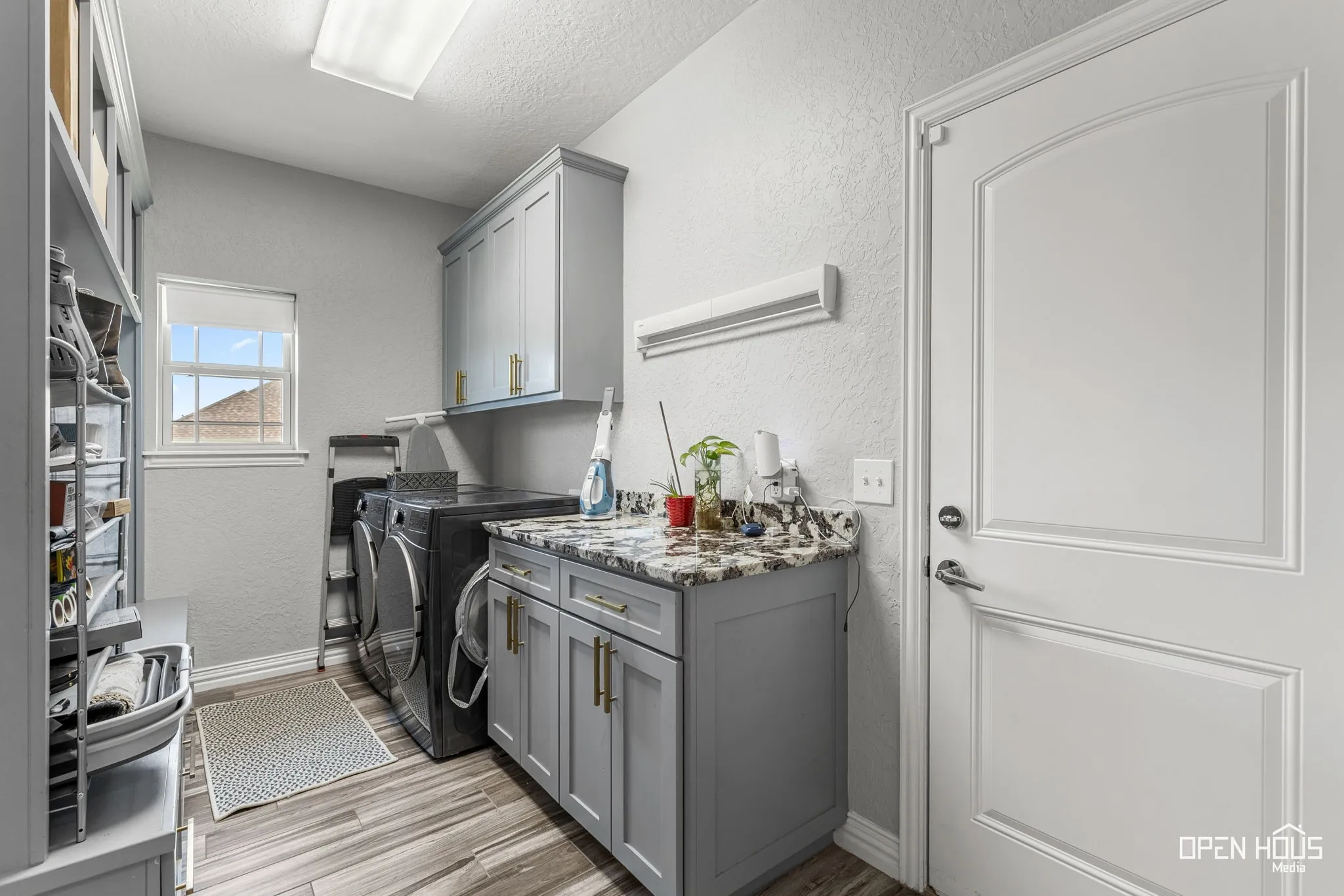 Laundry room featuring tile flooring, built-in cabinetry, a window, and a built-in counter with a stone-finish surface