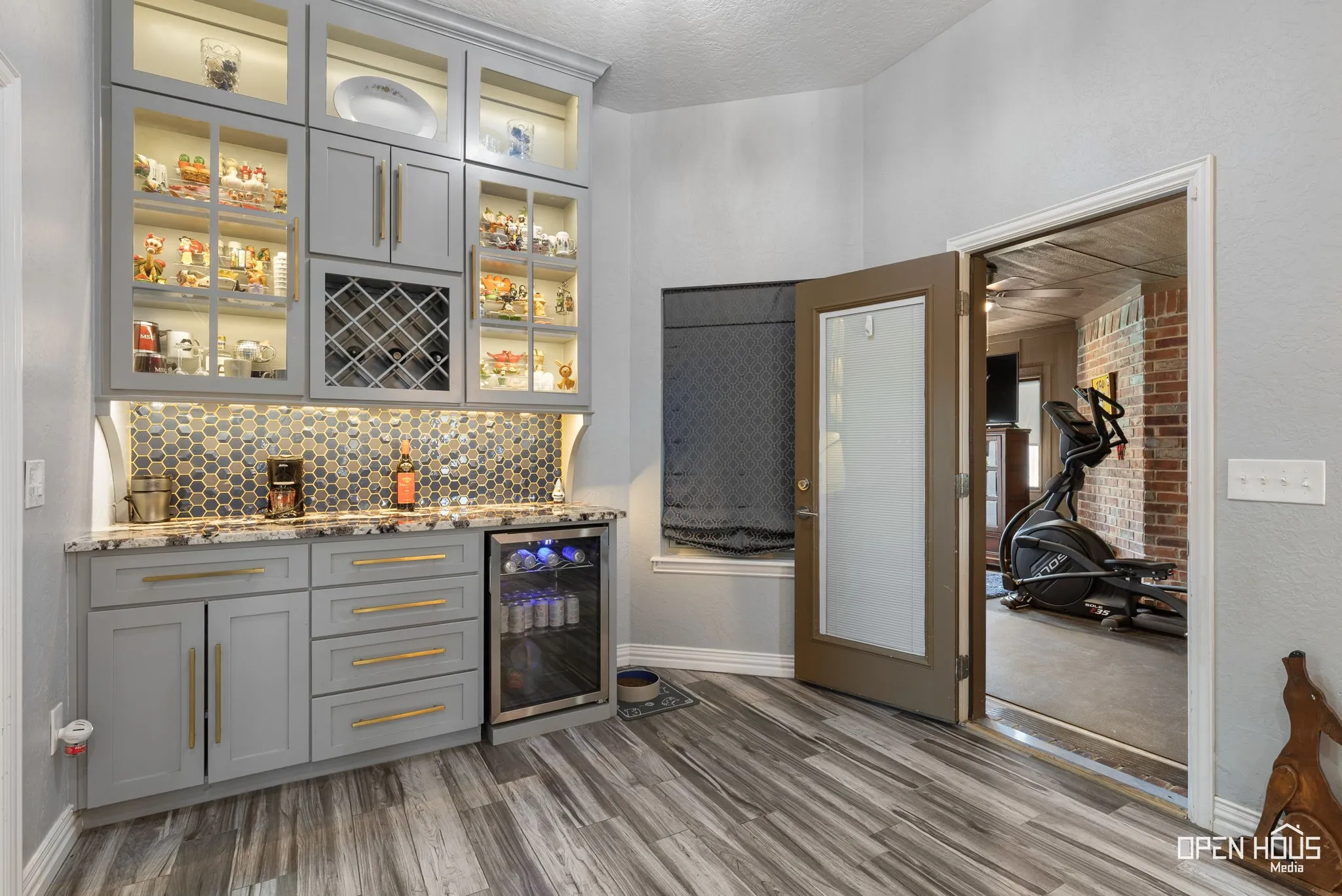 Custom built-in cabinetry with glass display fronts, integrated lighting, and a wine rack