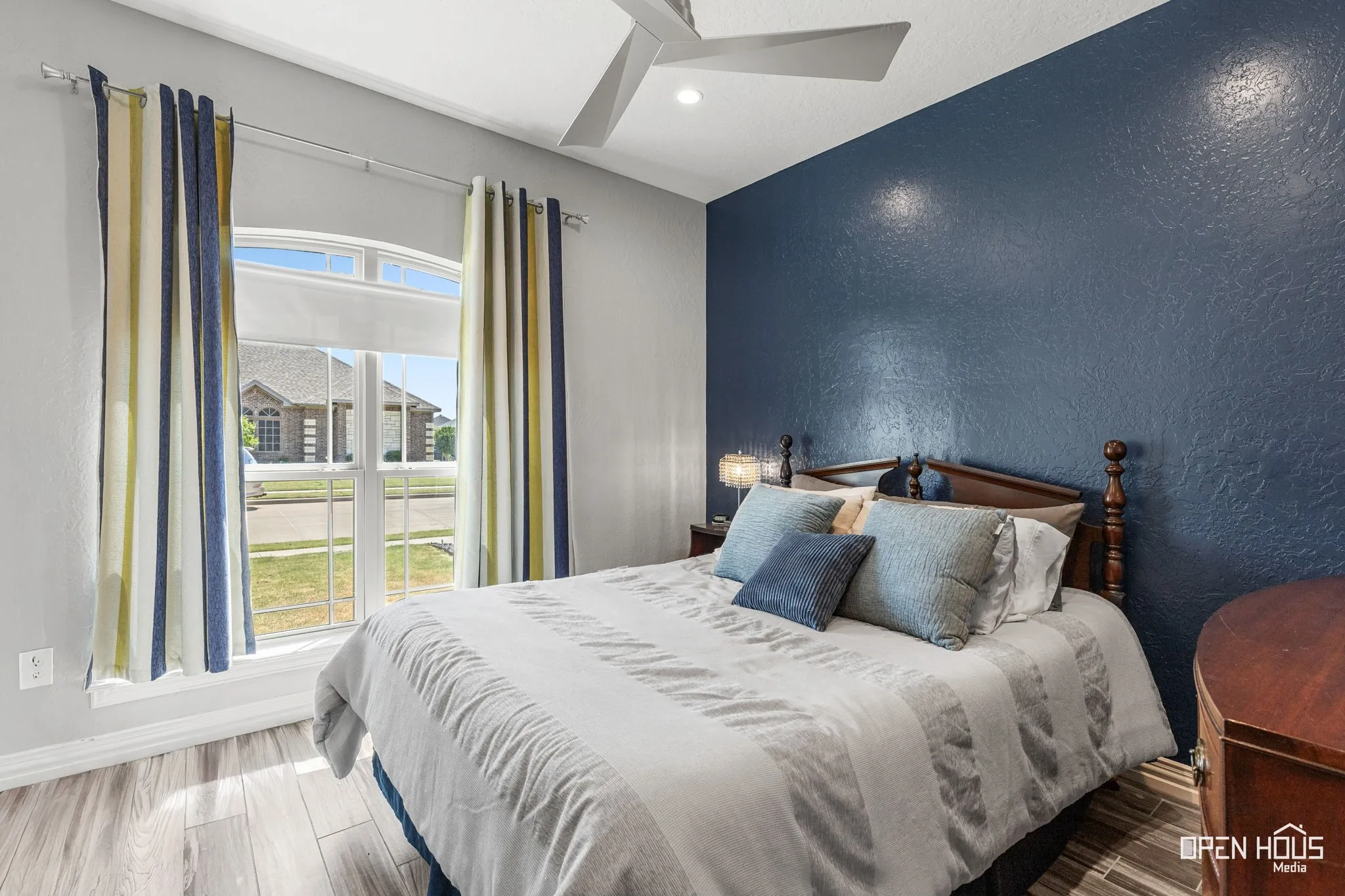 Arch-top window with transoms, tile flooring, and a ceiling fan with integrated lighting