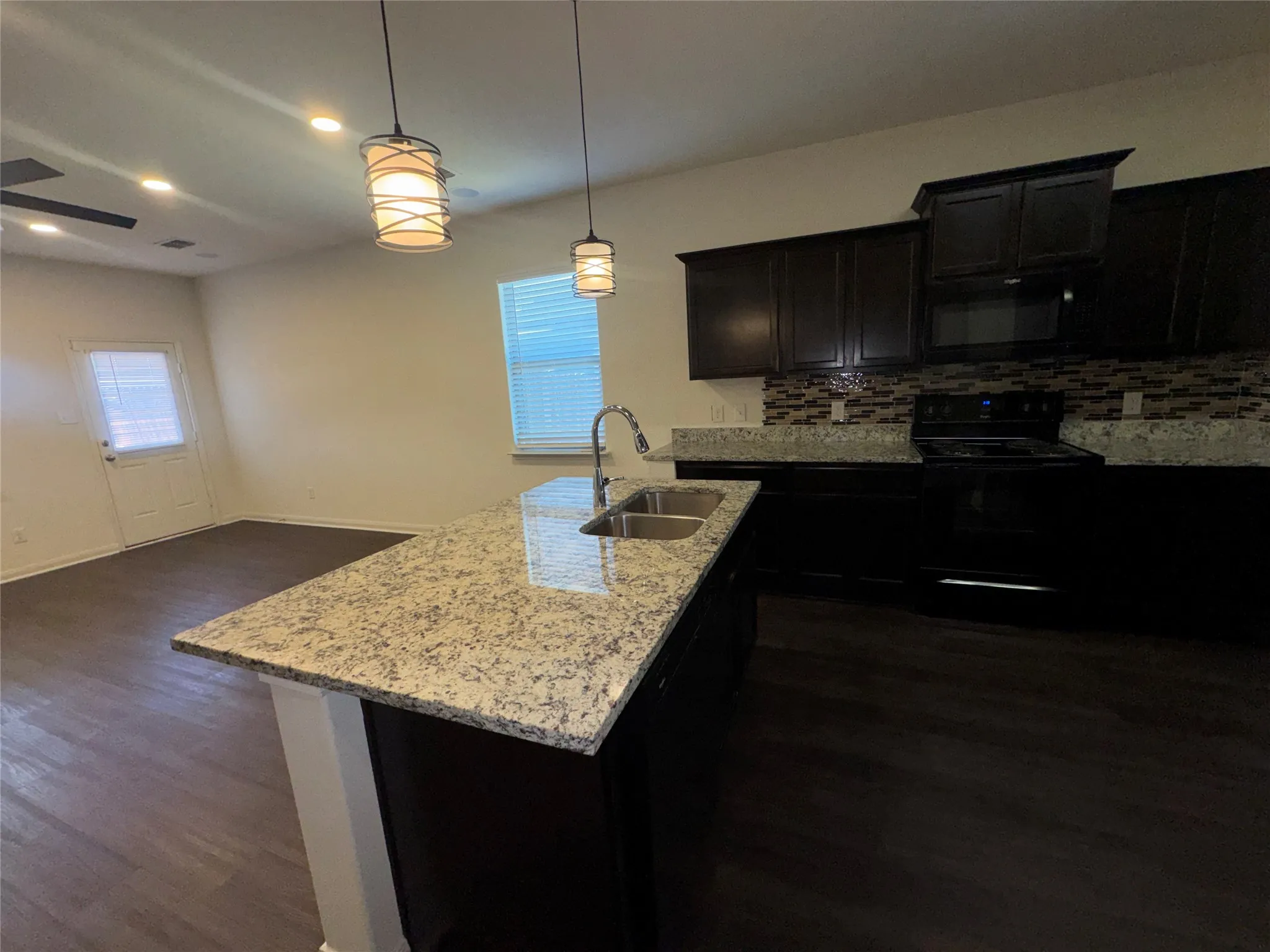 Kitchen island with stone-finish countertop and undermount double-basin sink