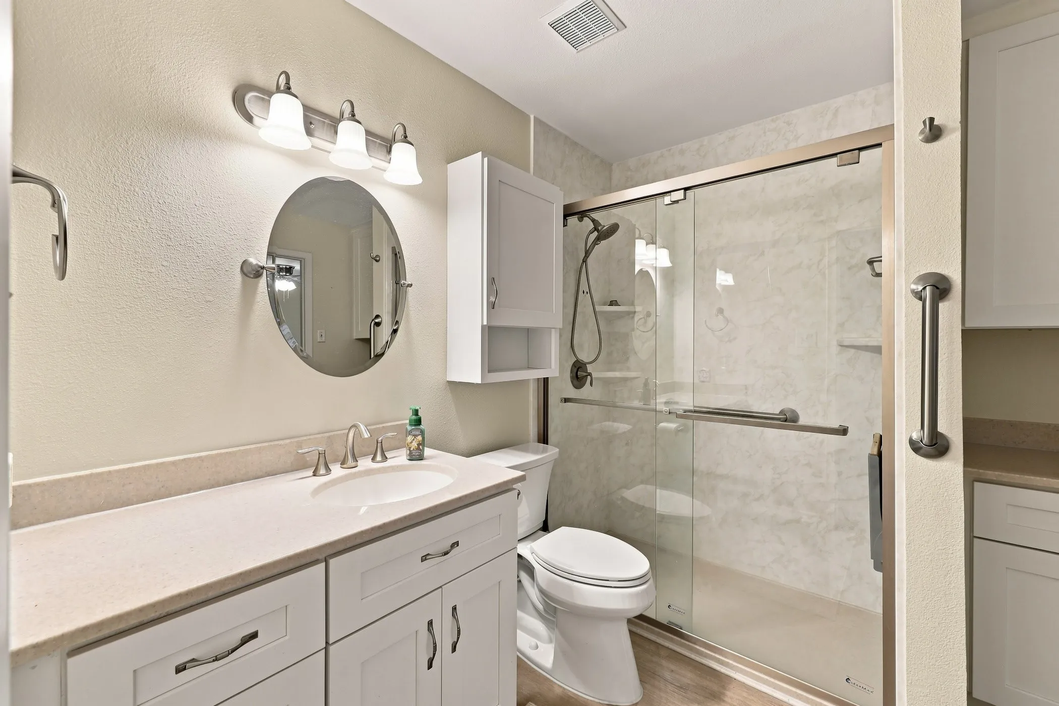 White shaker-style vanity with a light-toned countertop and integrated sink