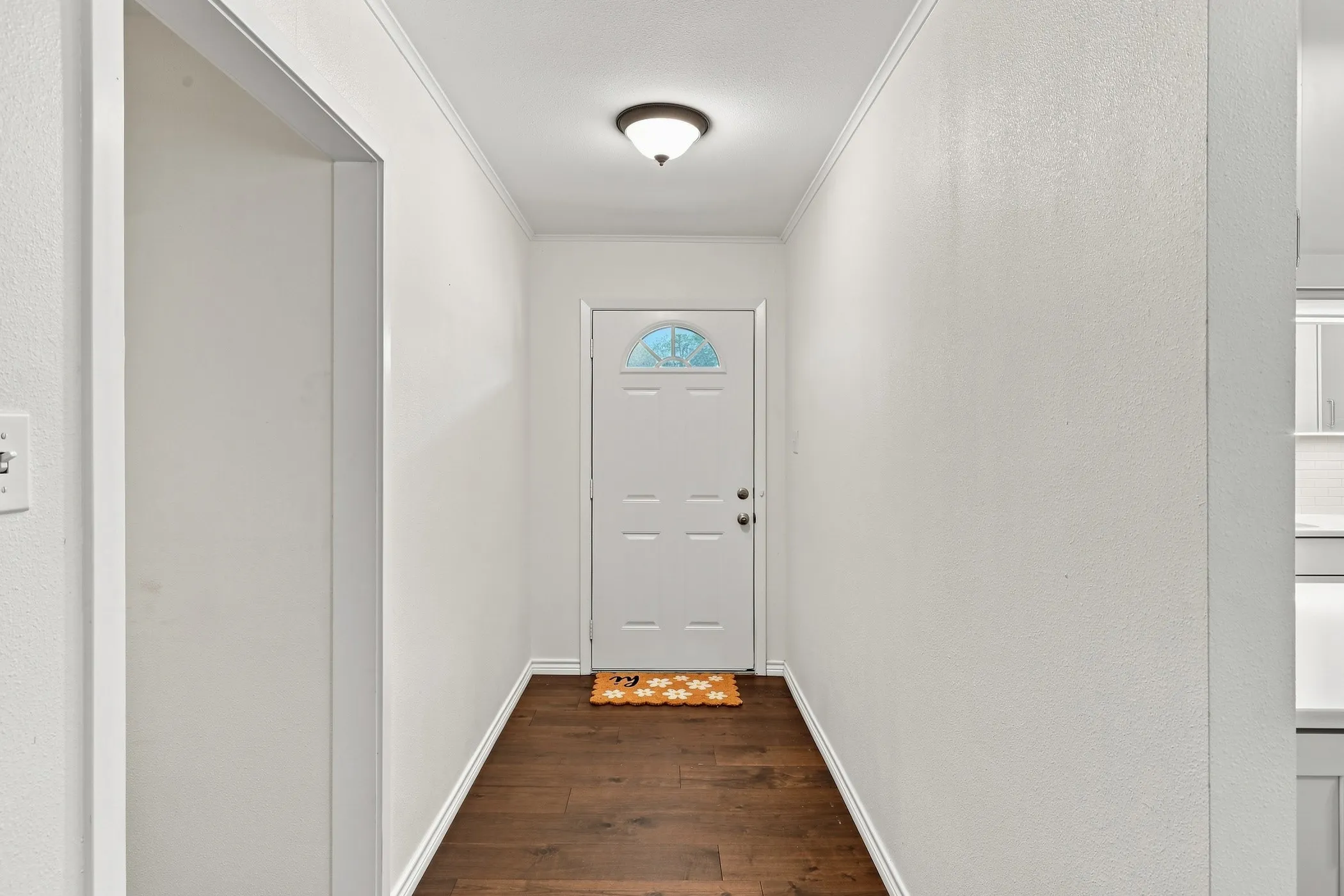 Foyer featuring wood-finish flooring, white walls, and a semi-flush mount ceiling light