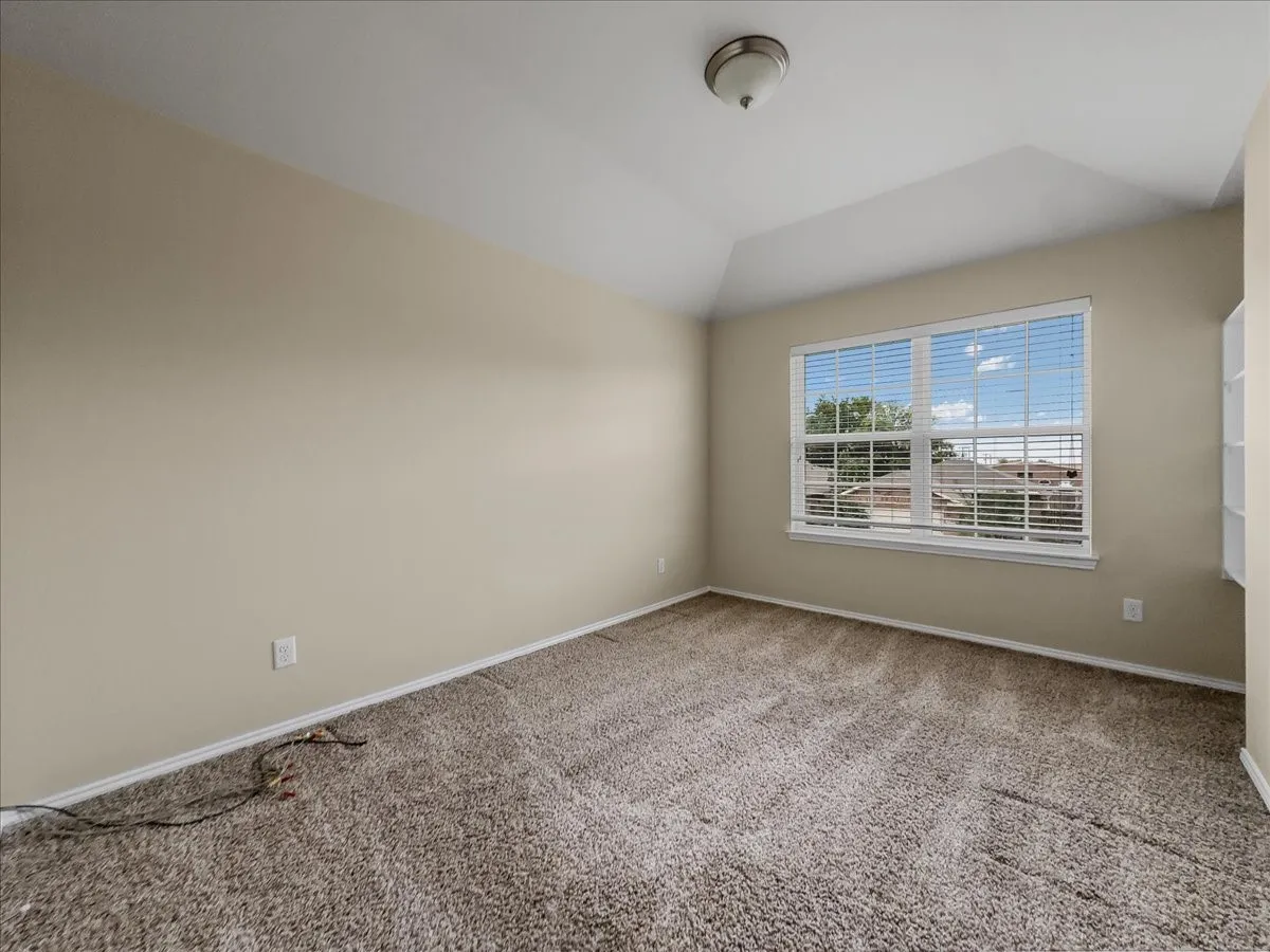 Neutral-toned carpeting, light-colored walls, and a window with blinds