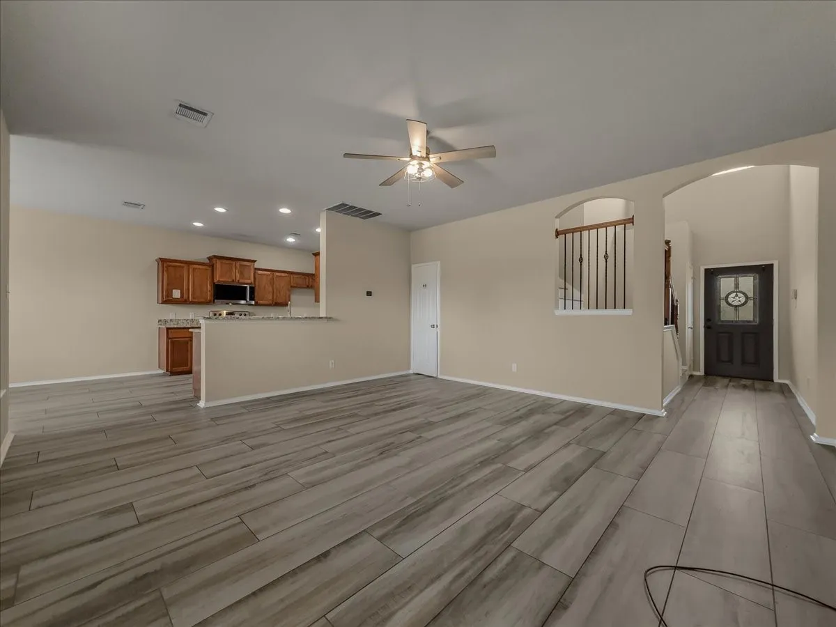 Wood-finish plank flooring, recessed lighting, and a ceiling fan