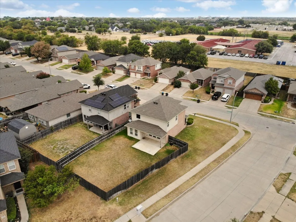 Two-story residence with a covered patio, fenced backyard, and solar panels