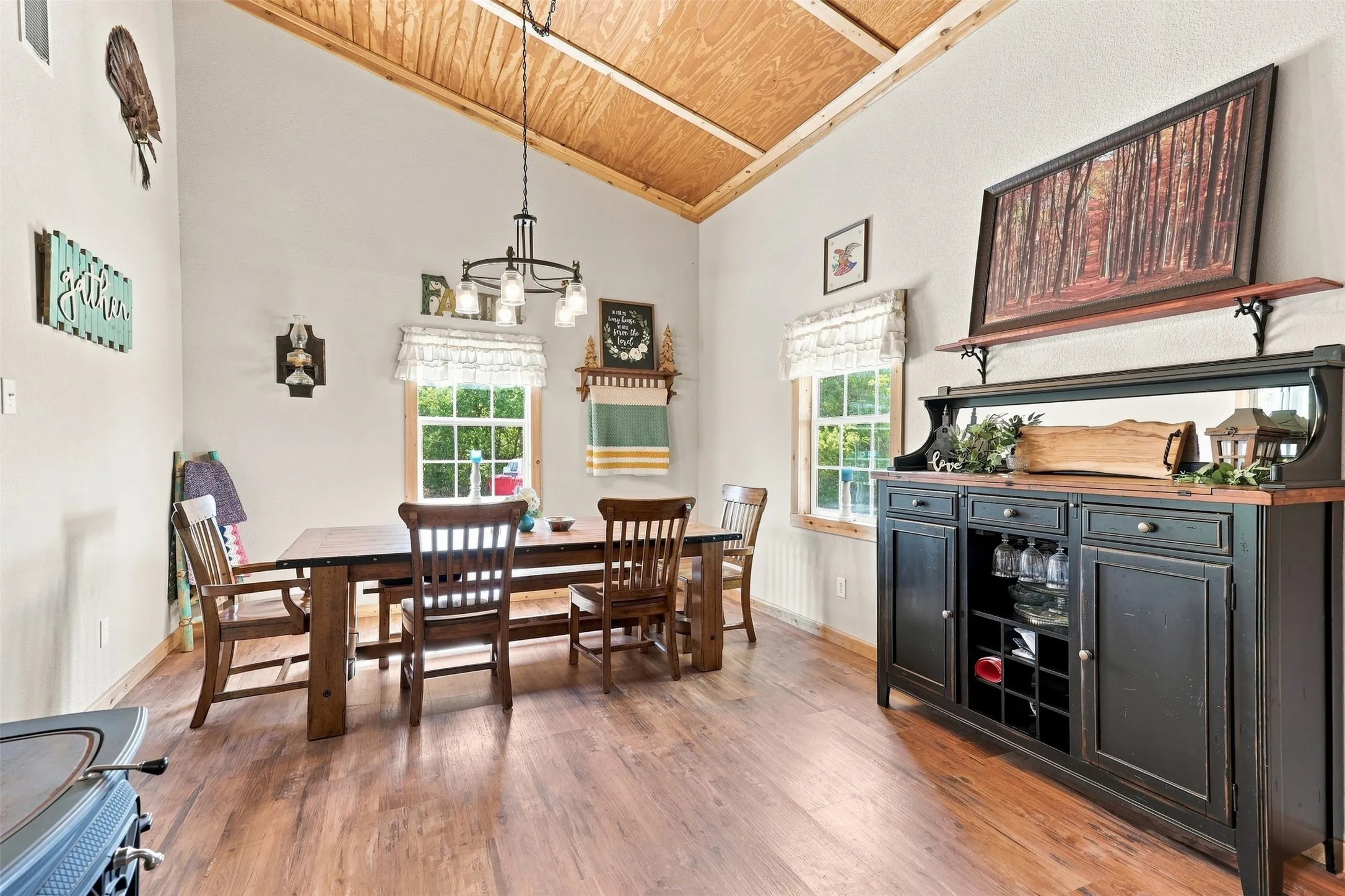 Vaulted wood-finish ceiling, wood-finish flooring, white walls, and a built-in buffet with storage