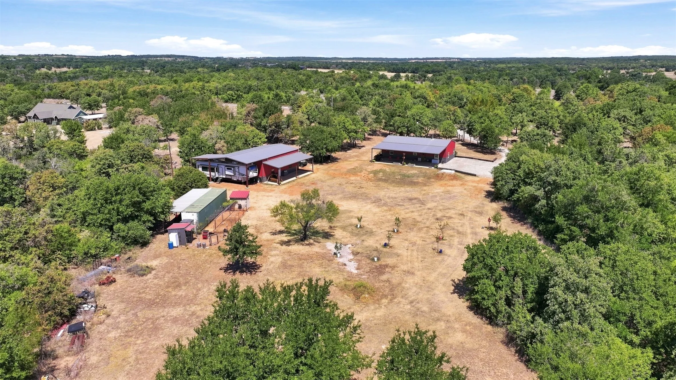Expansive property featuring multiple structures within a treed setting
