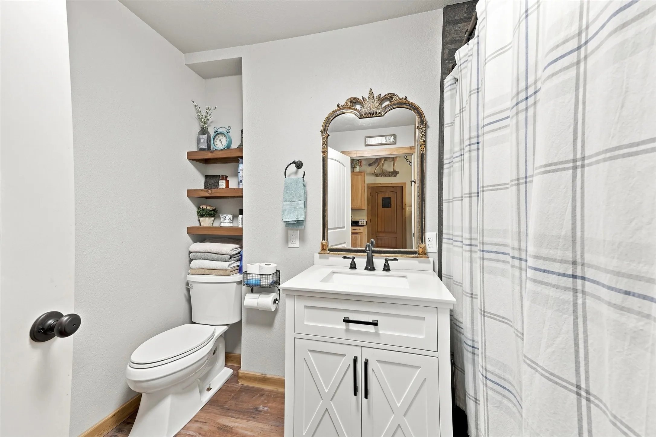 White vanity with shaker-style door fronts, black hardware, and an integrated sink