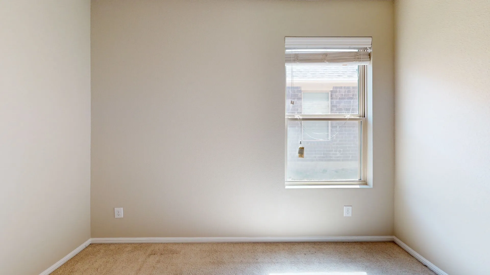 Bright, light-filled bedroom with large window featuring natural light and exterior visibility