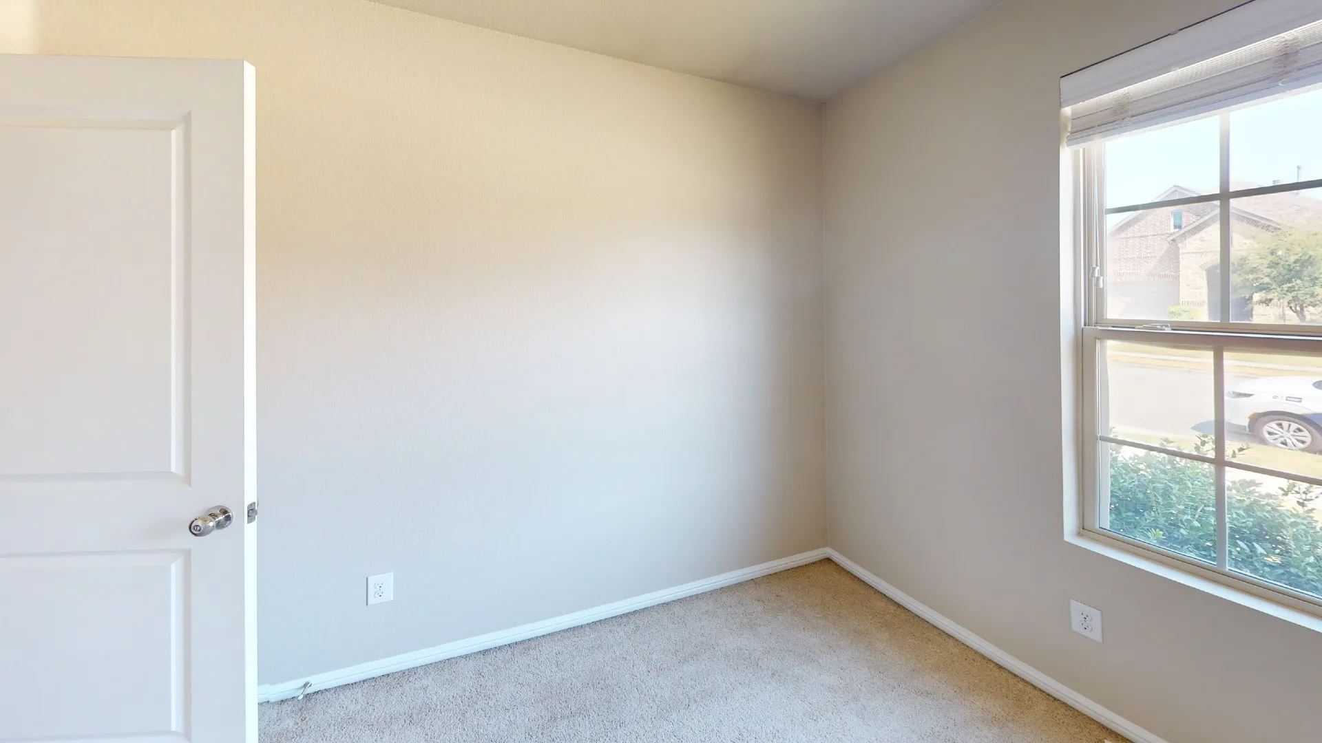 Warm neutral wall paint, carpet flooring, and a multi-pane window with blinds