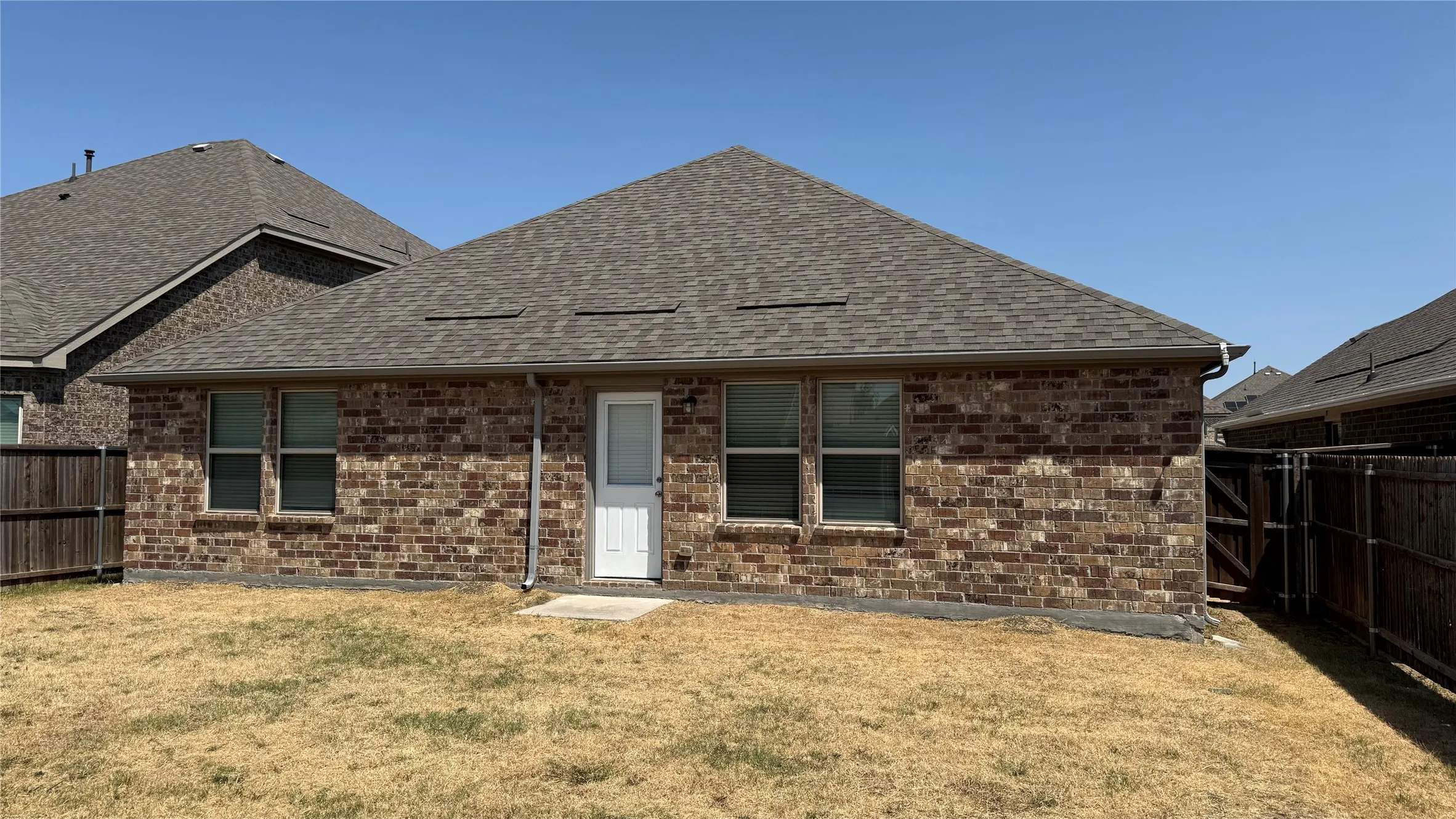 Brick exterior featuring a gabled roof and white door