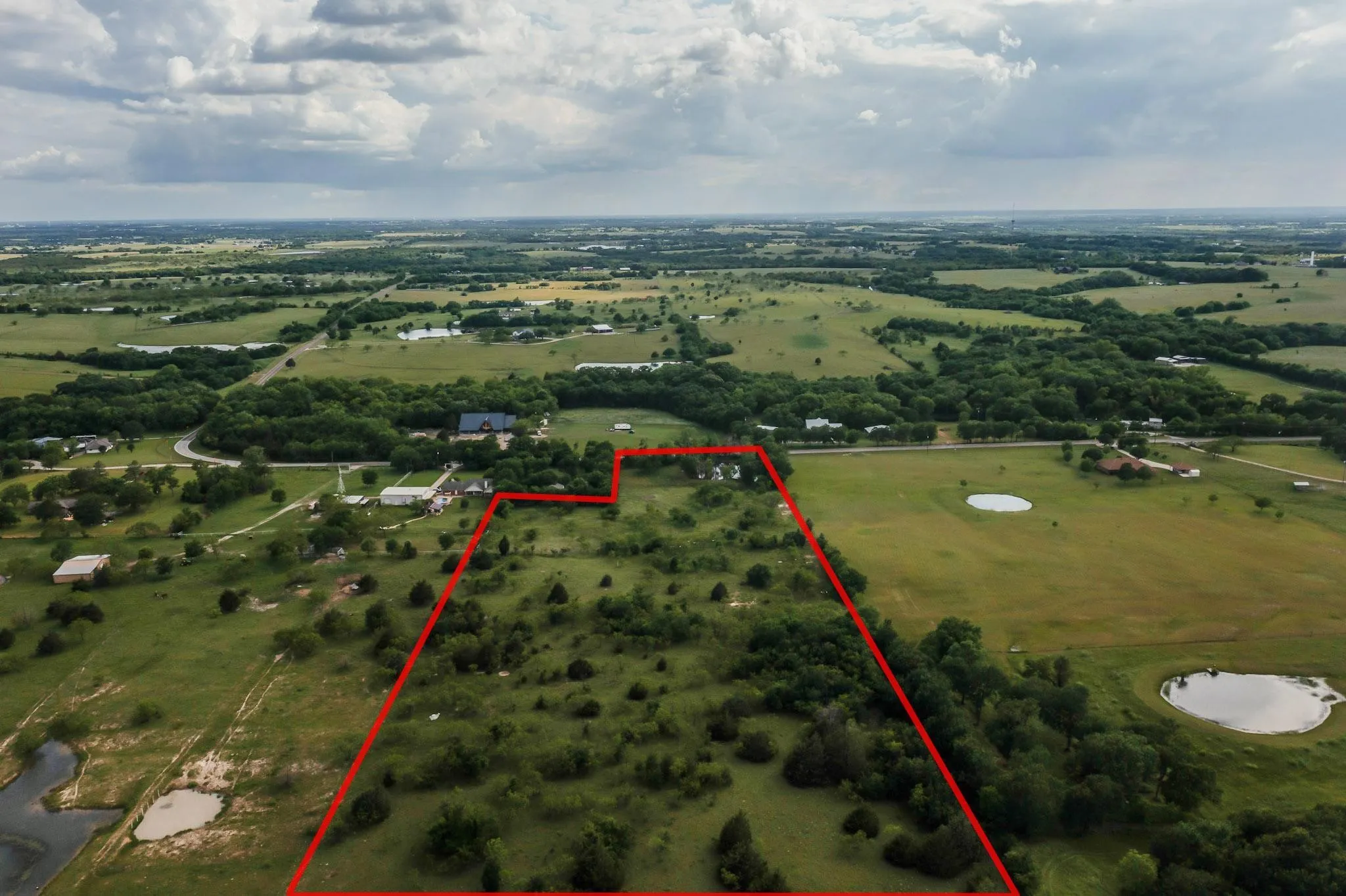 Expansive rural landscape with a mix of pasture and wooded terrain