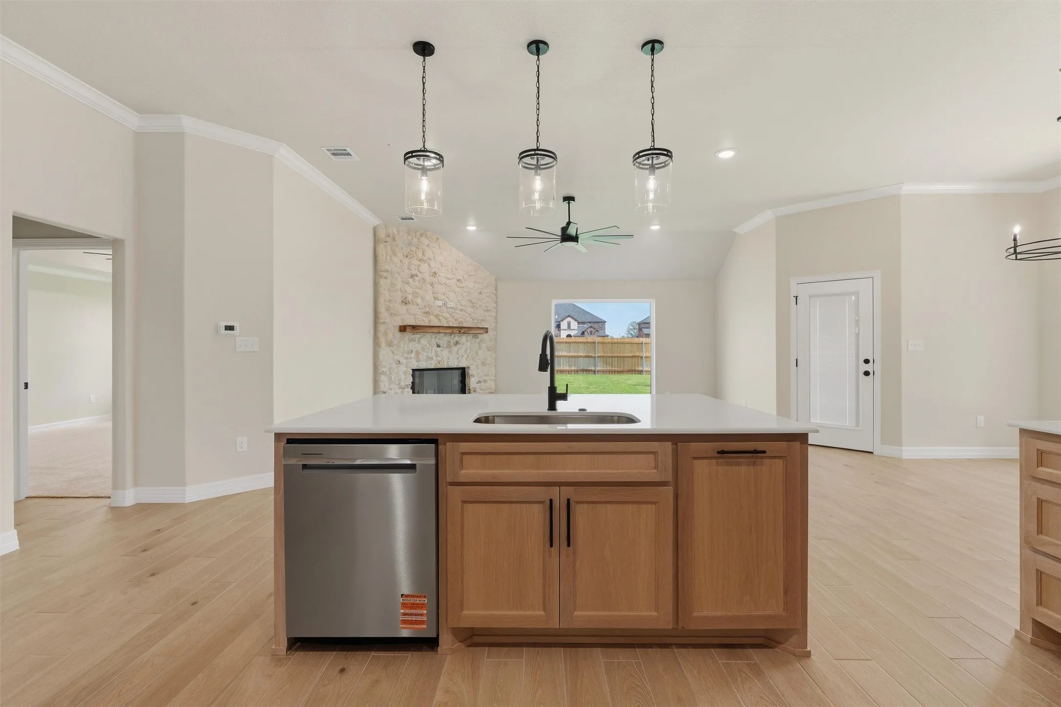 Kitchen island with integrated stainless steel dishwasher, undermount sink, and wood-finish cabinetry