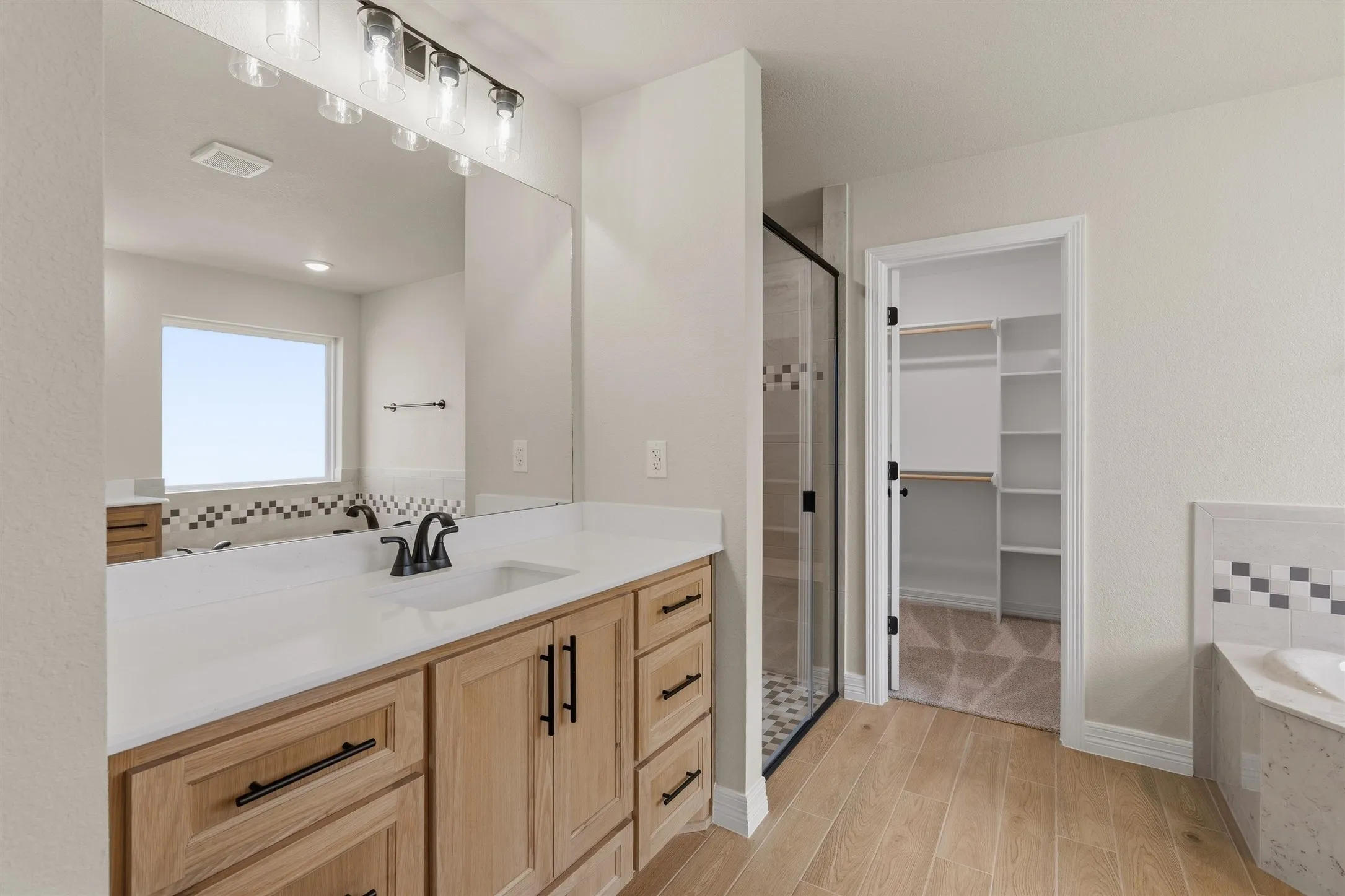 Dual vanity with light wood-finish cabinetry and quartz countertops