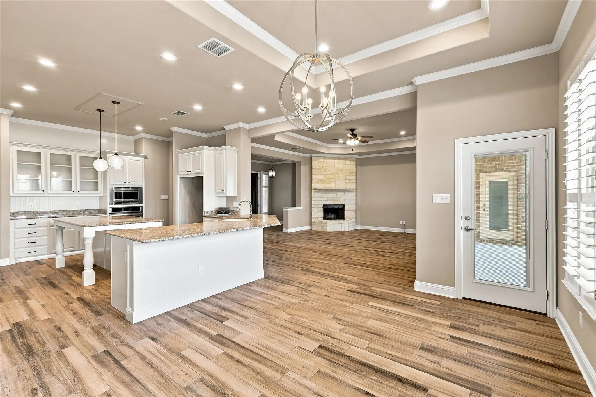 Rear view of the dining area with a door to covered back patio and view of the kitchen bartop counters.