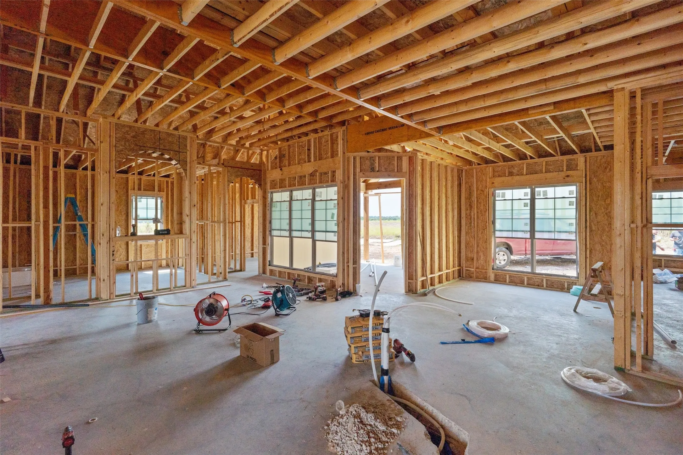 New construction framing with multiple window openings and an arched doorway