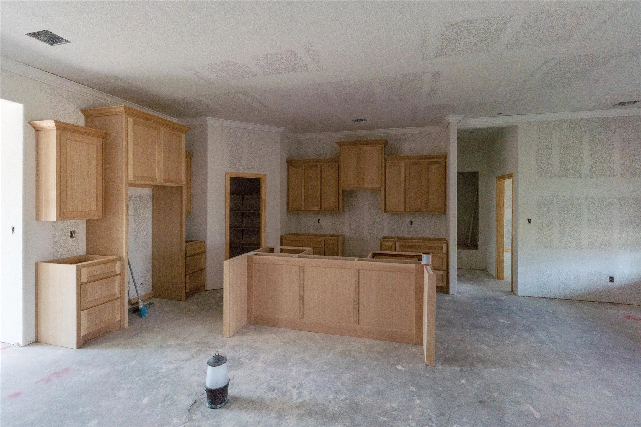 Kitchen featuring light wood cabinetry, a central island structure, and crown molding