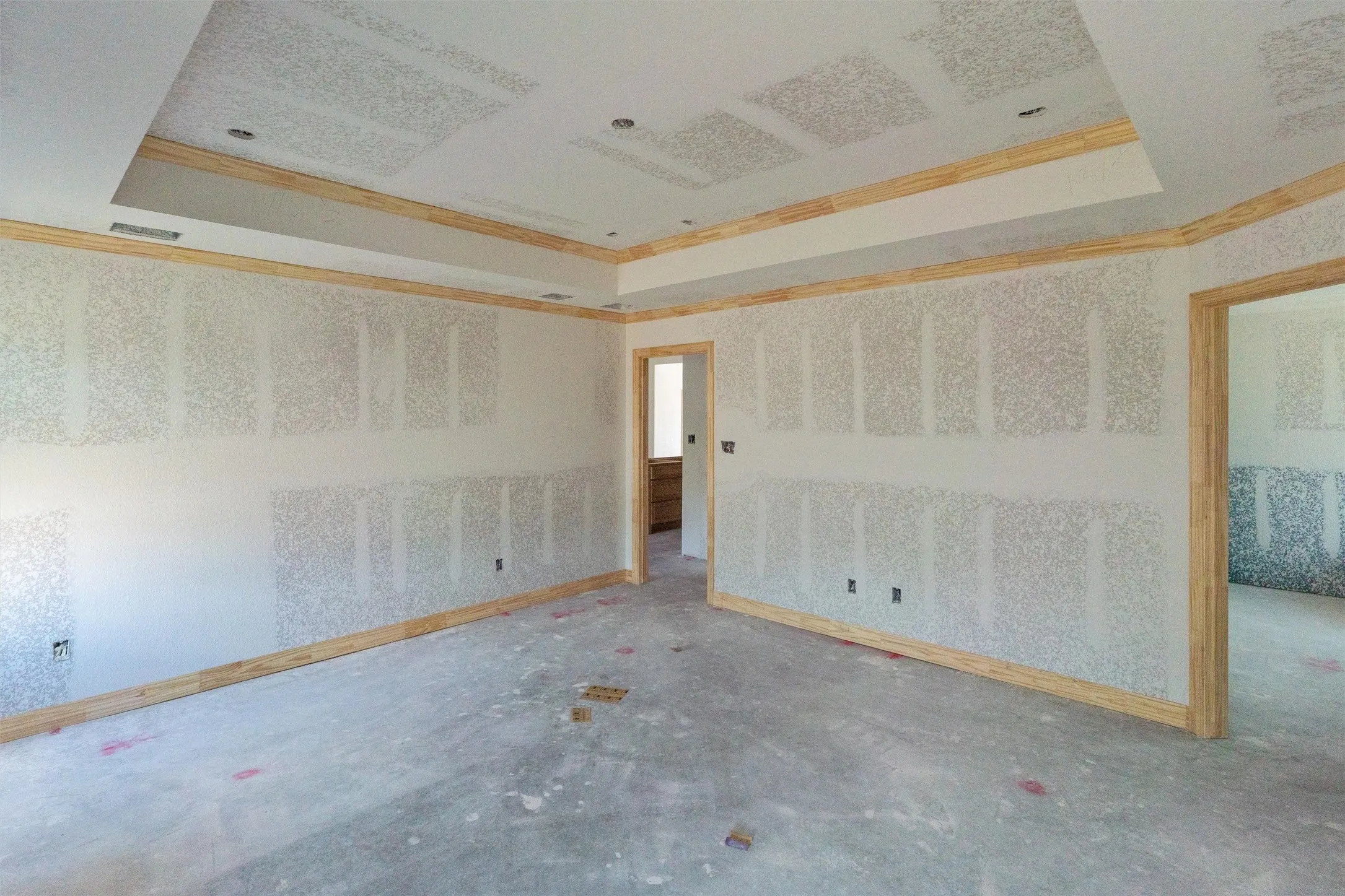 Tray ceiling with recessed lighting, crown molding, and unfinished walls