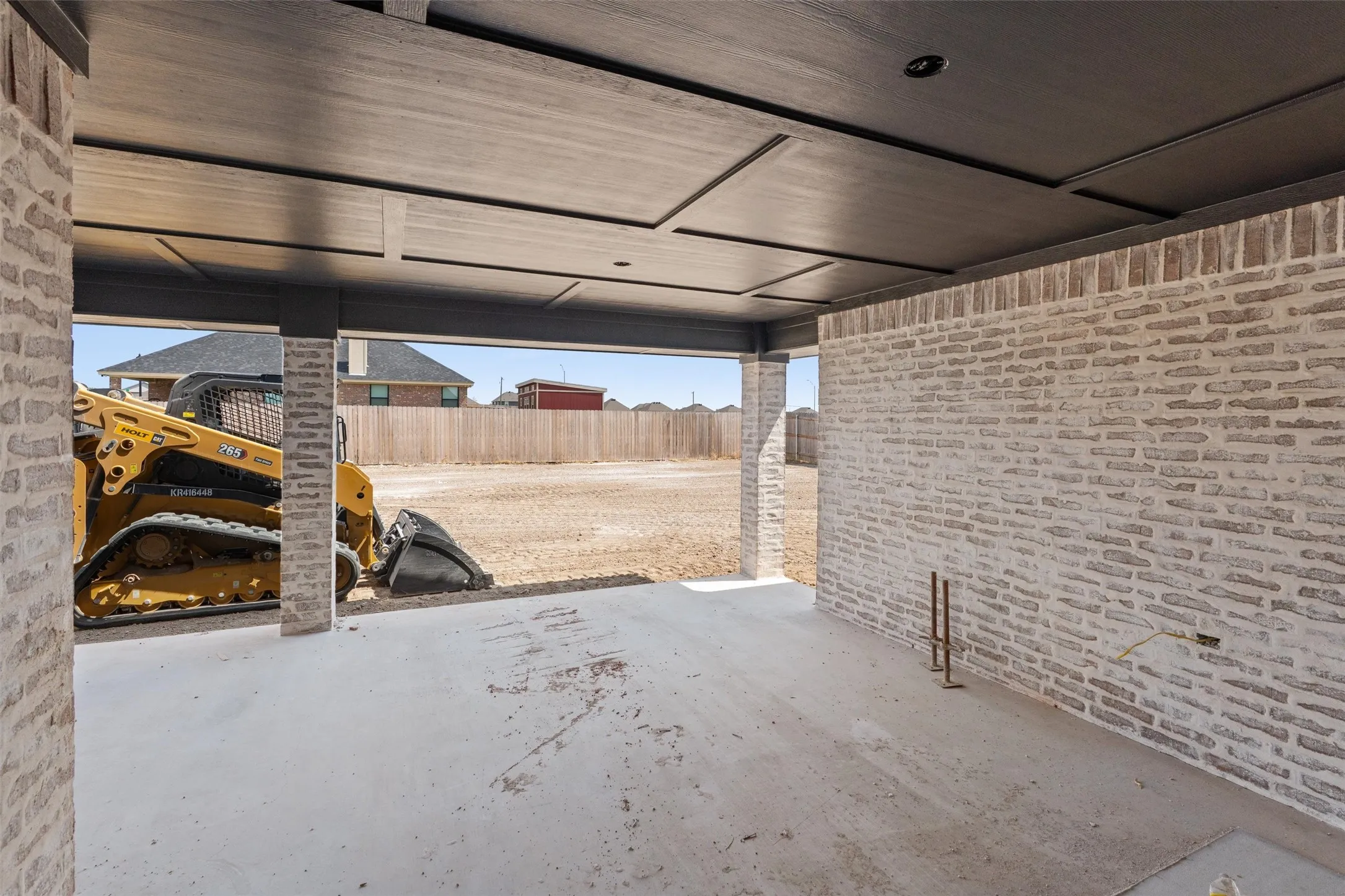 Exposed brick walls, concrete flooring, recessed lighting, and a detailed ceiling panel design
