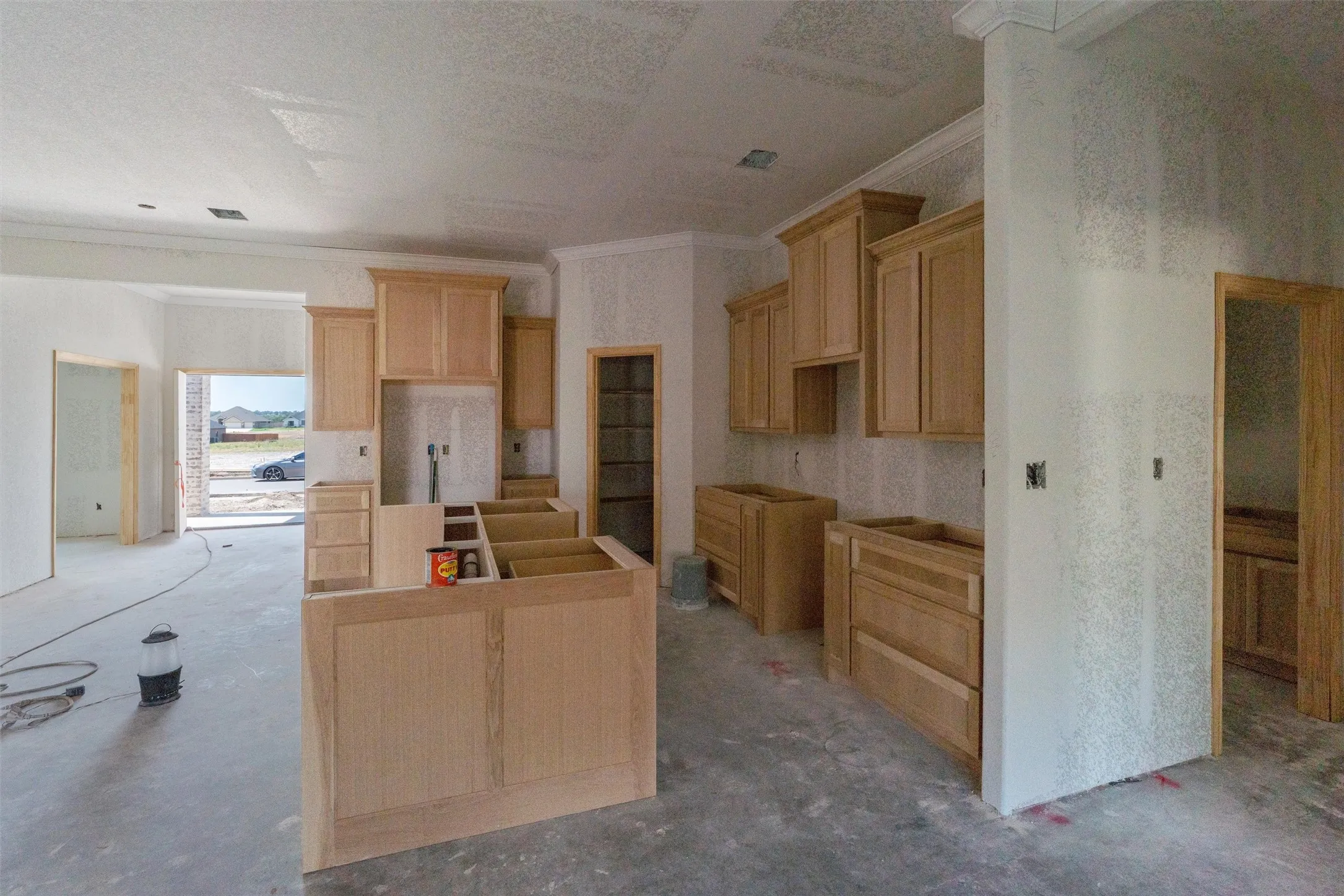 Kitchen featuring light wood cabinetry, center island, and arched doorway