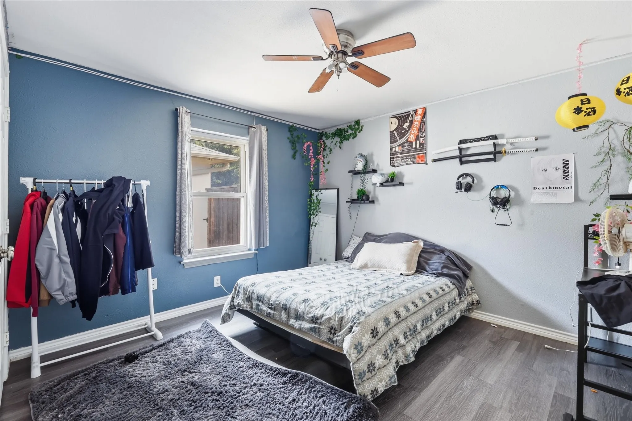Wood-finish flooring, ceiling fan with light fixture, and a window with blinds