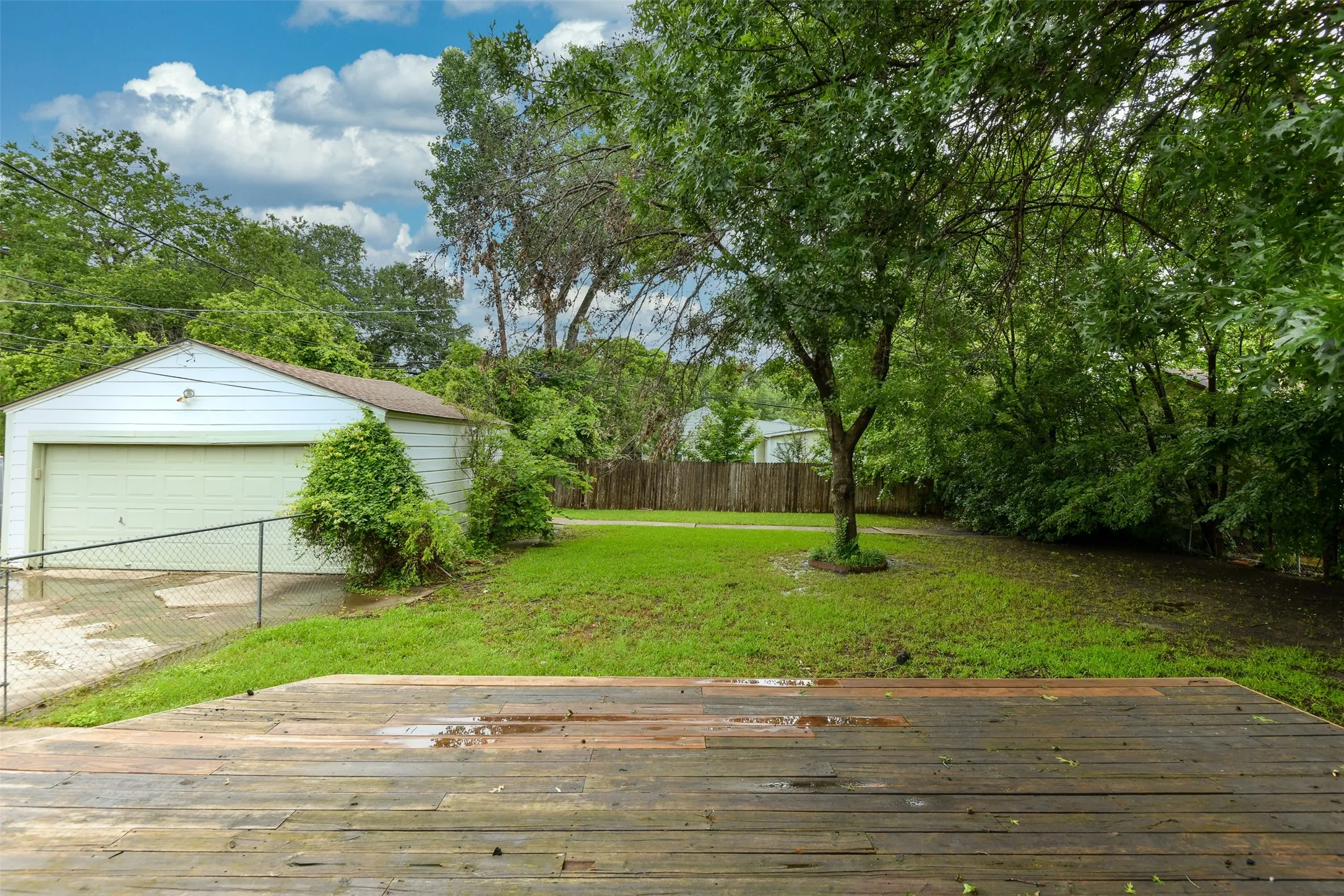 View of yard with an outbuilding, a garage, and a deck