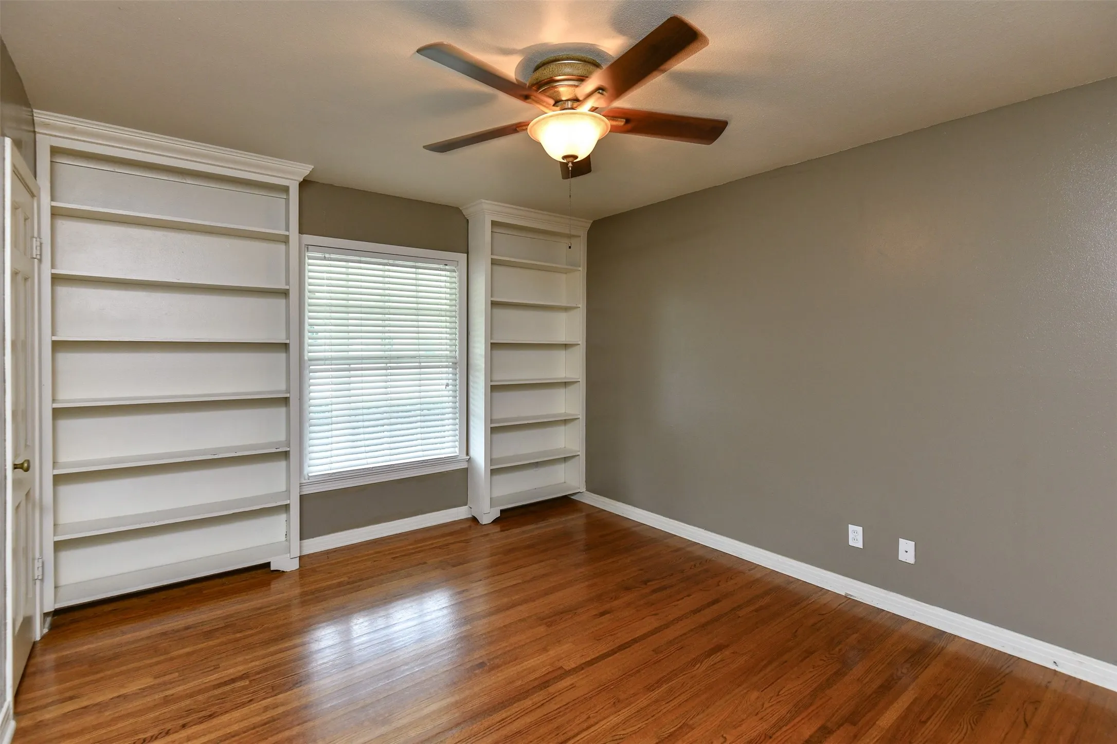Unfurnished bedroom with ceiling fan and hardwood / wood-style flooring