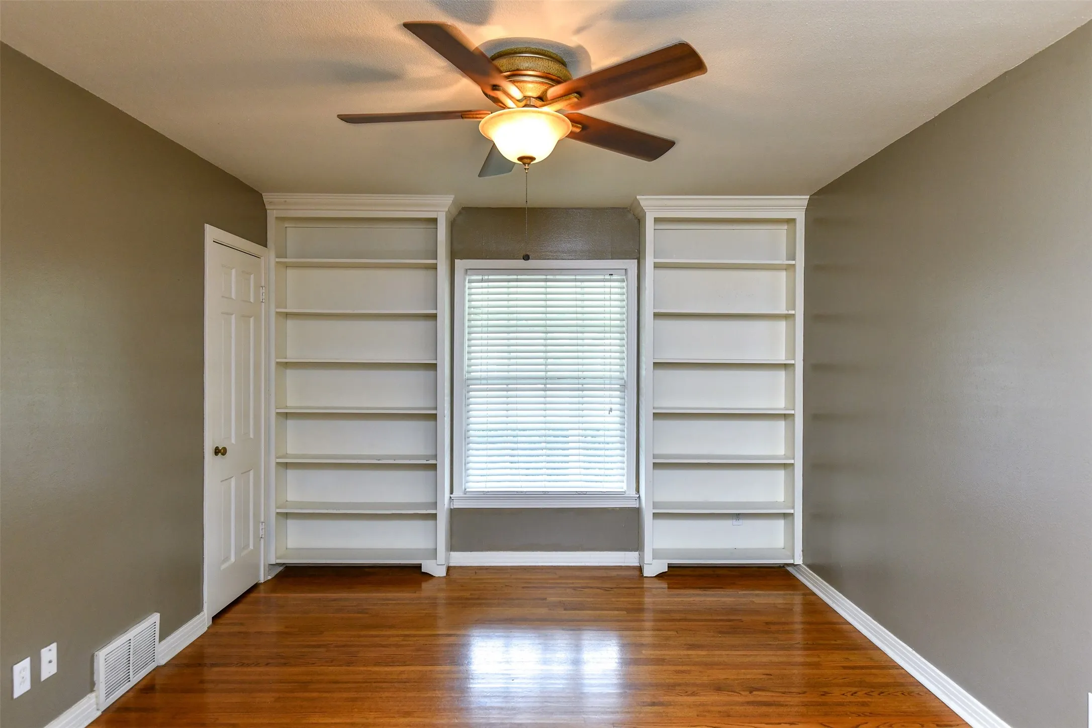 Unfurnished bedroom with dark hardwood / wood-style flooring and ceiling fan