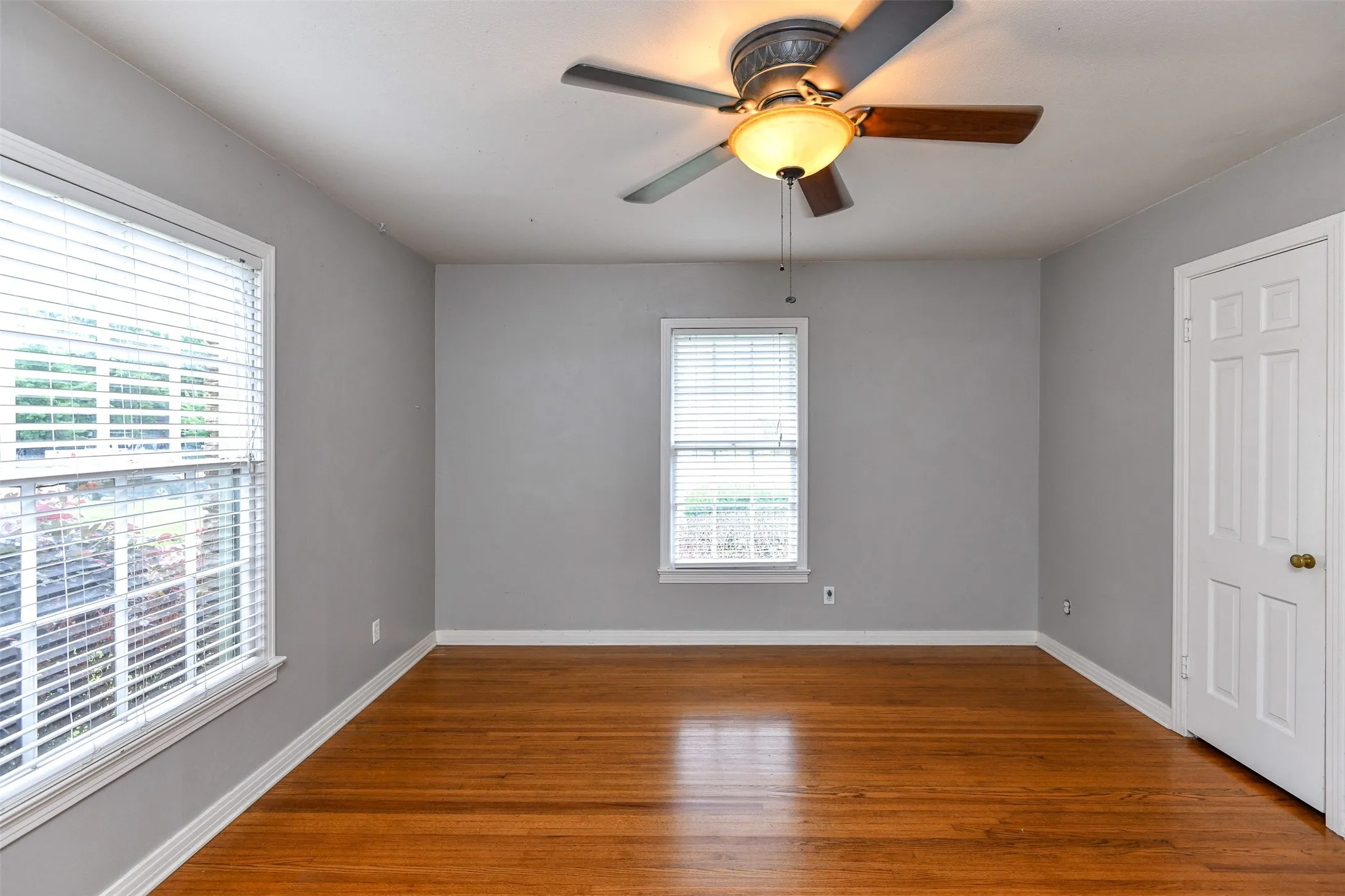 Empty room featuring hardwood / wood-style flooring and ceiling fan