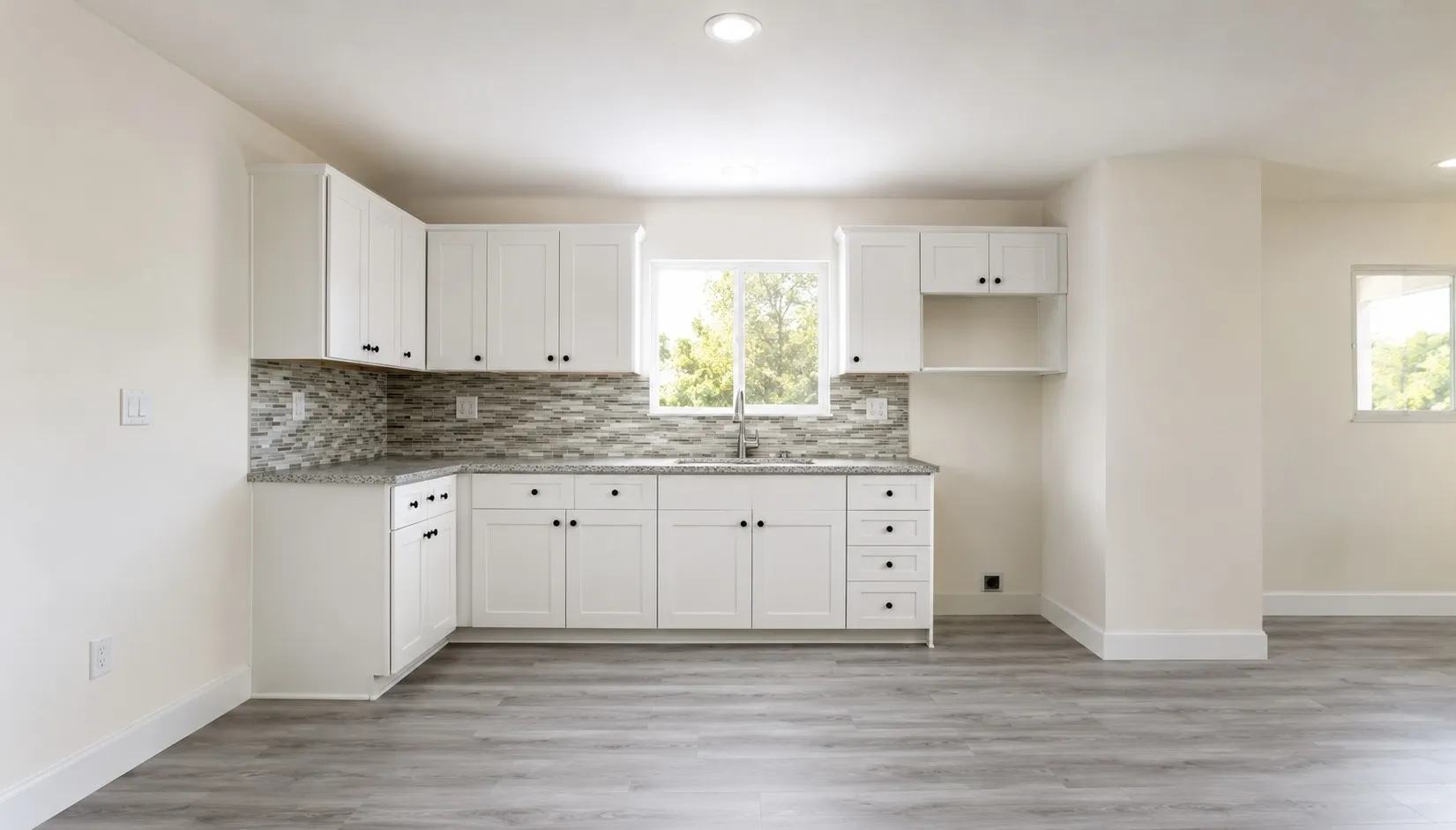 Contemporary kitchen featuring white cabinetry, a mosaic tile backsplash, speckled countertops, and wood-finish flooring
