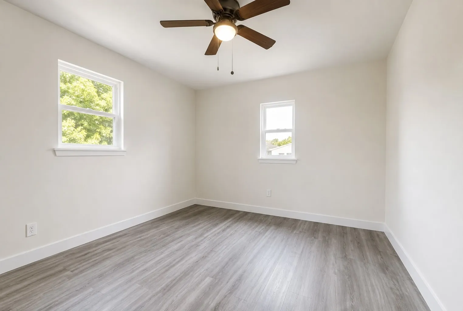 Wood-finish flooring, white walls, and a ceiling fan with integrated lighting