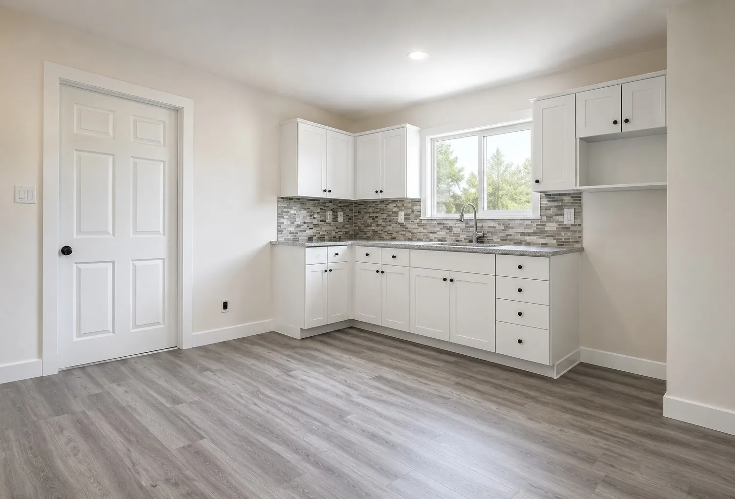 Kitchen featuring white cabinetry, grey wood-finish flooring, a mosaic tile backsplash, and a stainless steel sink with a pull-down faucet