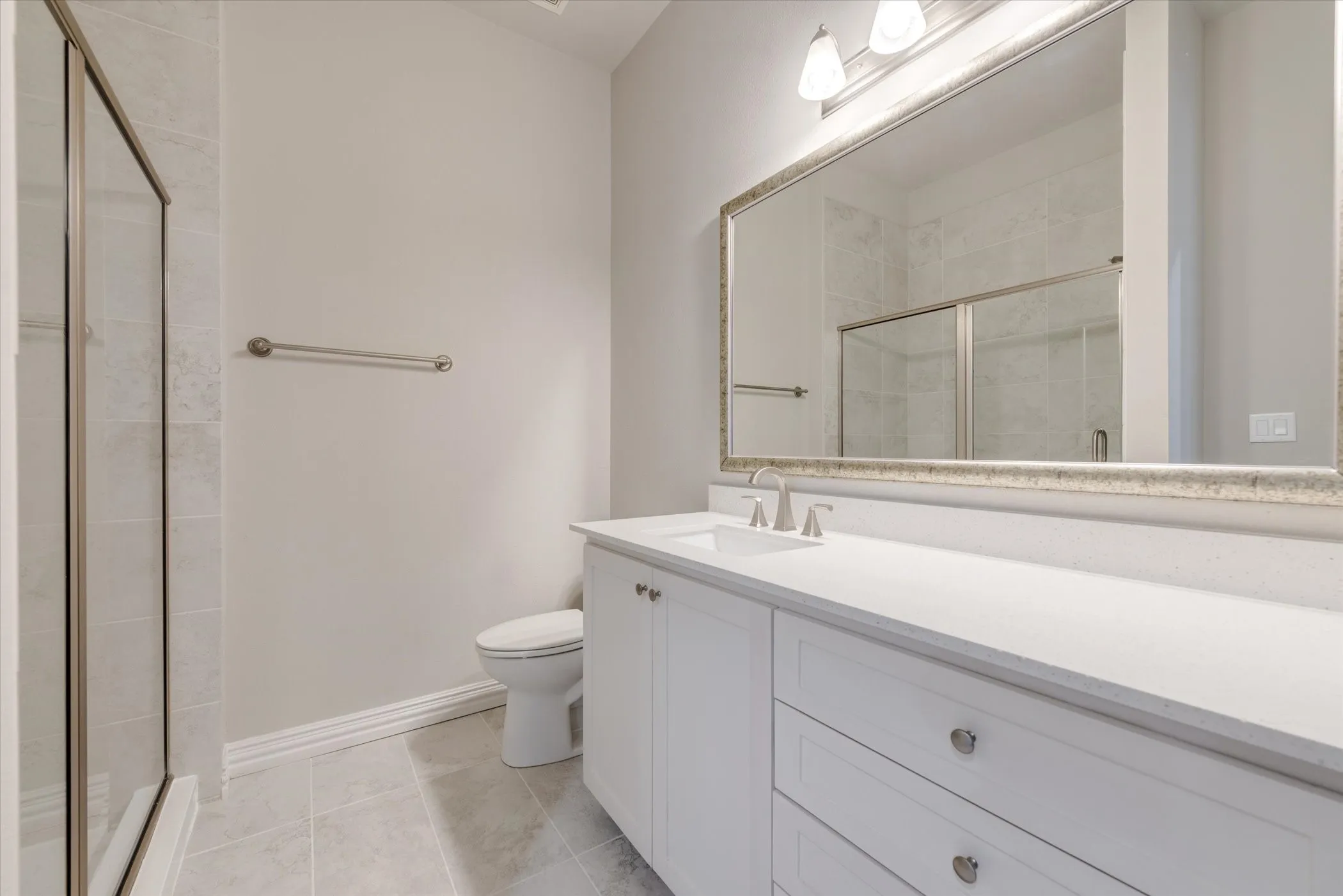 Double vanity with white cabinetry, a light-toned countertop, and undermount sinks