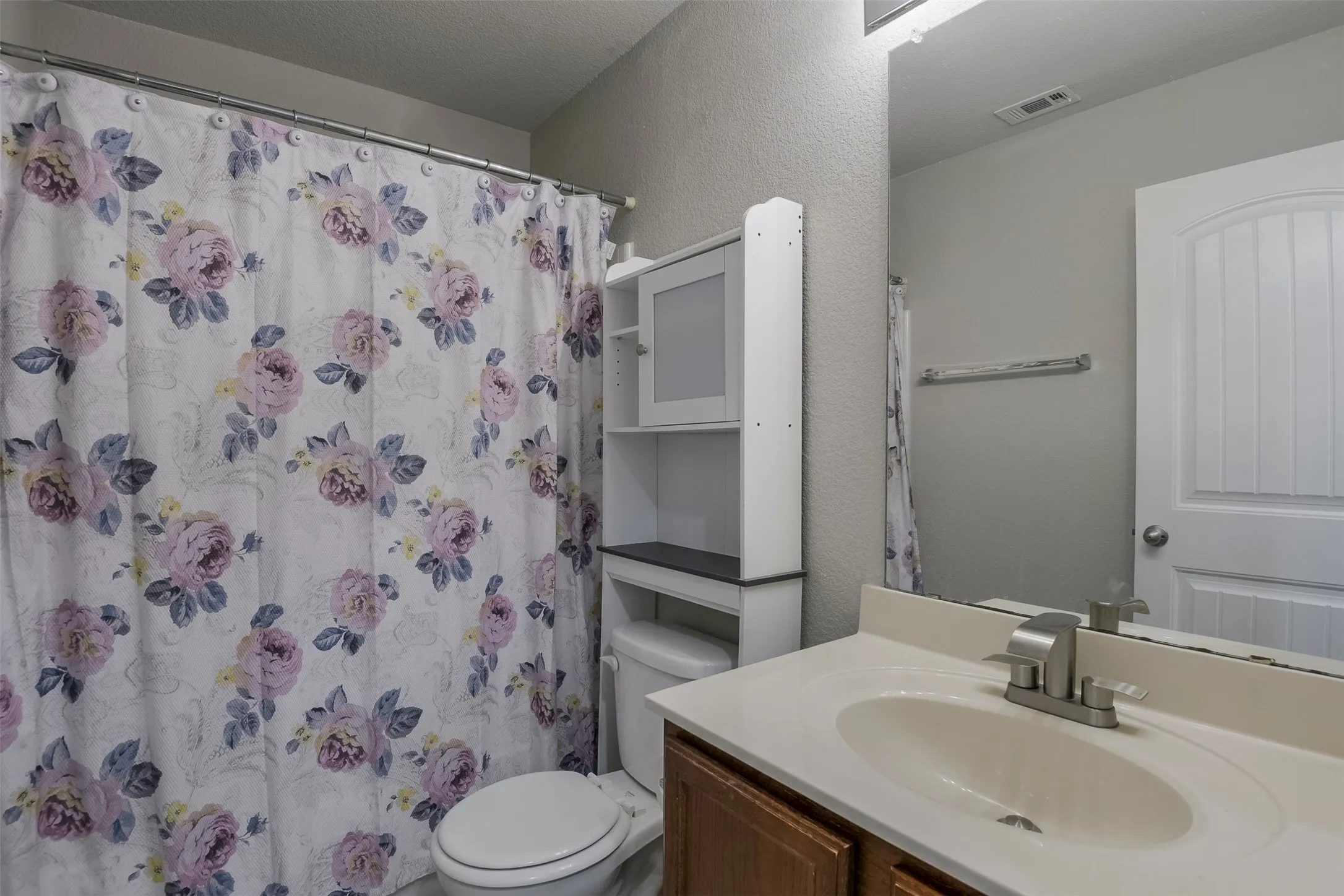 Bathroom featuring a vanity with a drop-in sink, brushed nickel faucet, wood cabinet, and a framed mirror