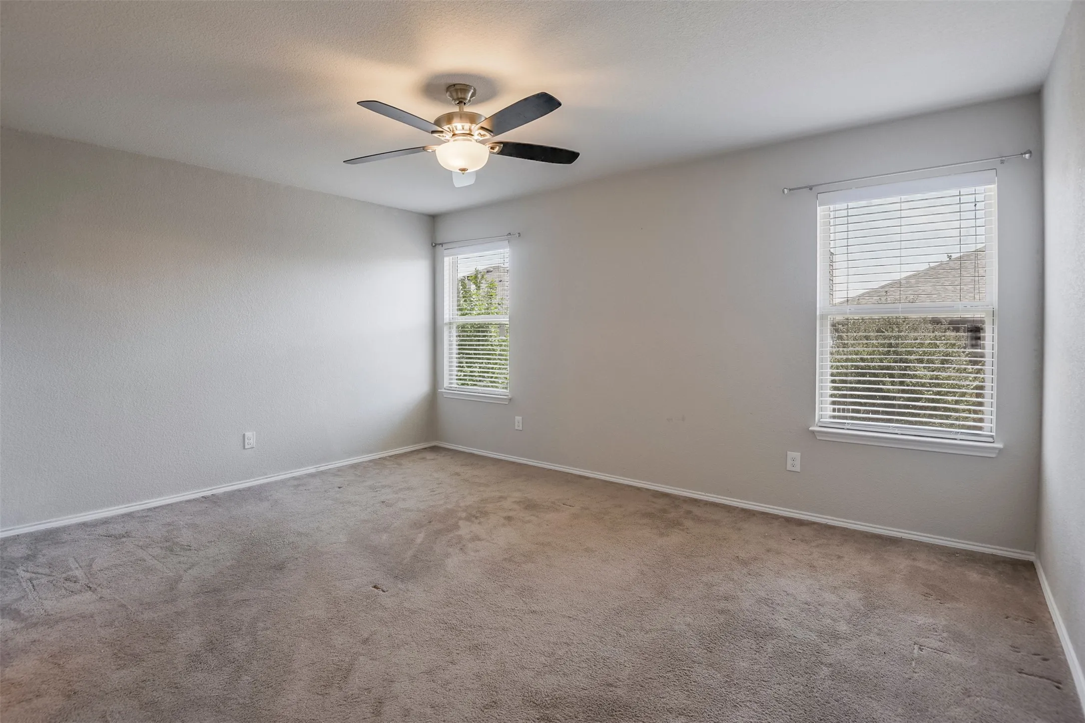 Recessed lighting, ceiling fan with integrated light fixture, and two windows with blinds