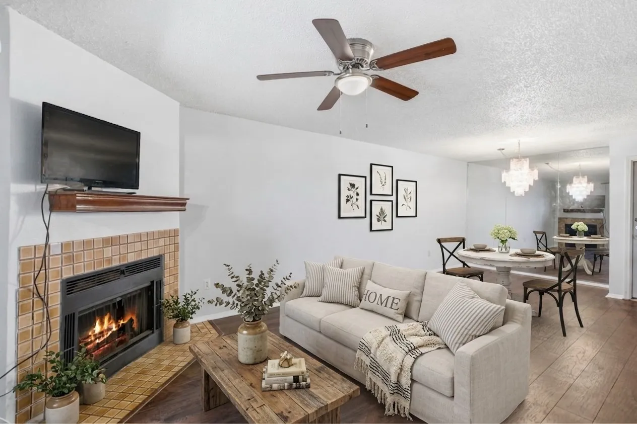 Living area featuring a tile-surround fireplace with a wood mantel, dark wood-finish flooring, and a ceiling fan with integrated lighting