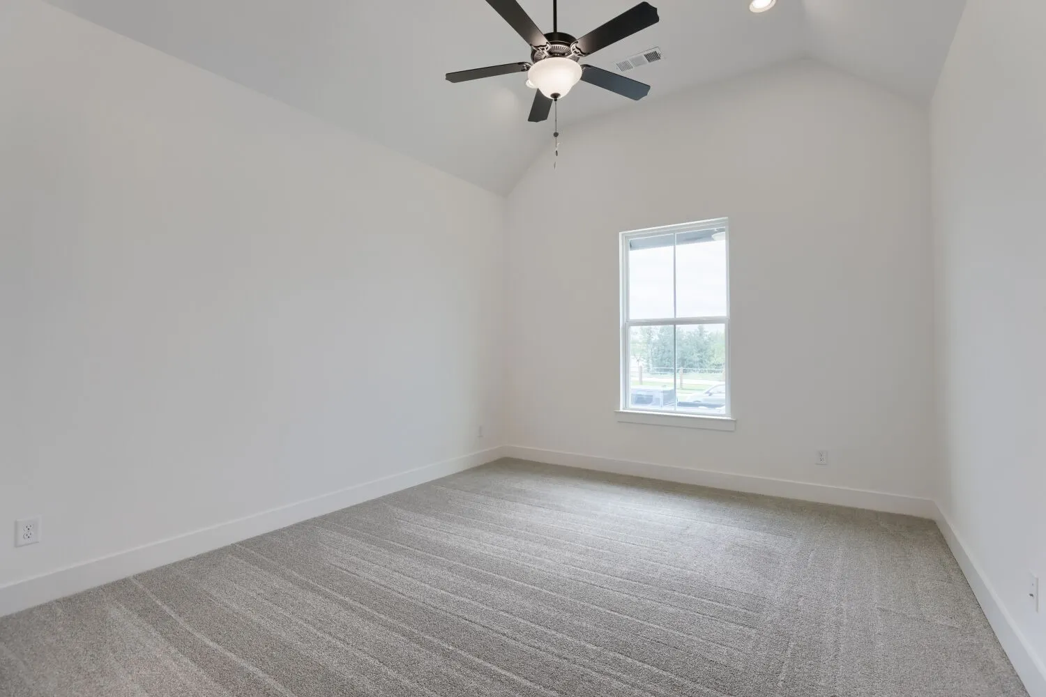 Vaulted ceiling with a ceiling fan light fixture, recessed lighting, and a window with white trim