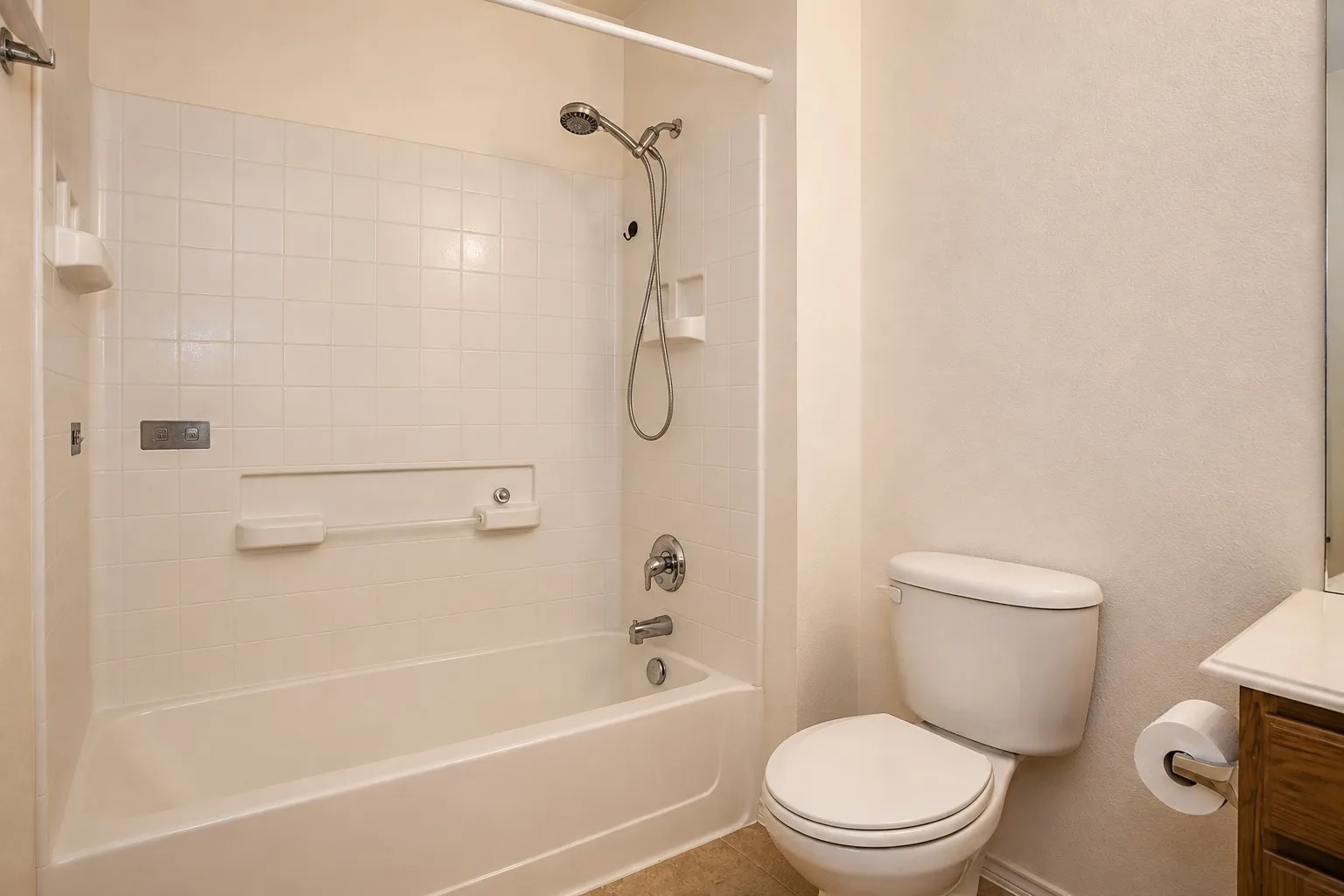Bathtub with a tiled surround, integrated shelving, and a chrome showerhead