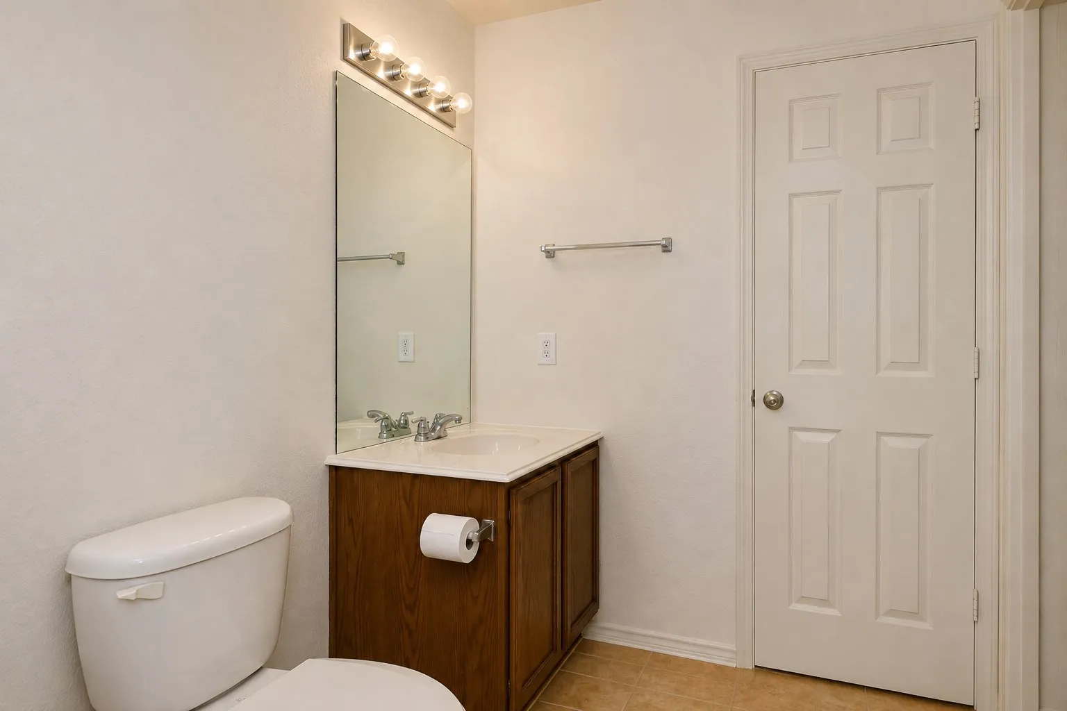 Vanity with wood-finish cabinetry, integrated sink, and brushed metal faucet