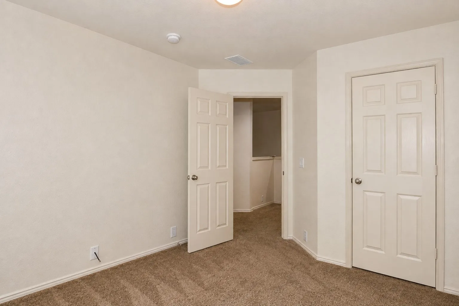 Textured wall finishes with neutral paint, six-panel interior doors, and plush carpet flooring